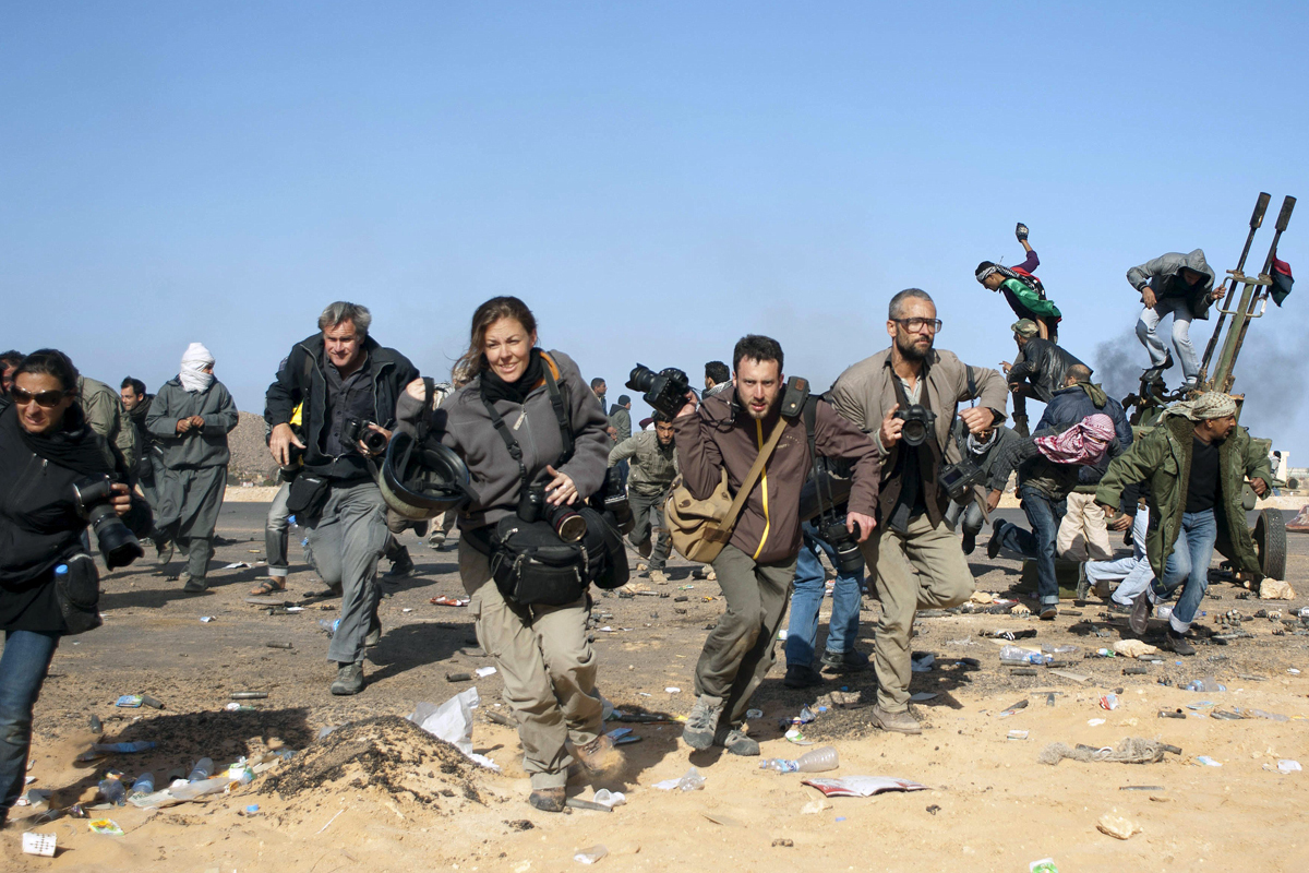Periodistas cubren un bombardeo del gobierno libio en 2011.