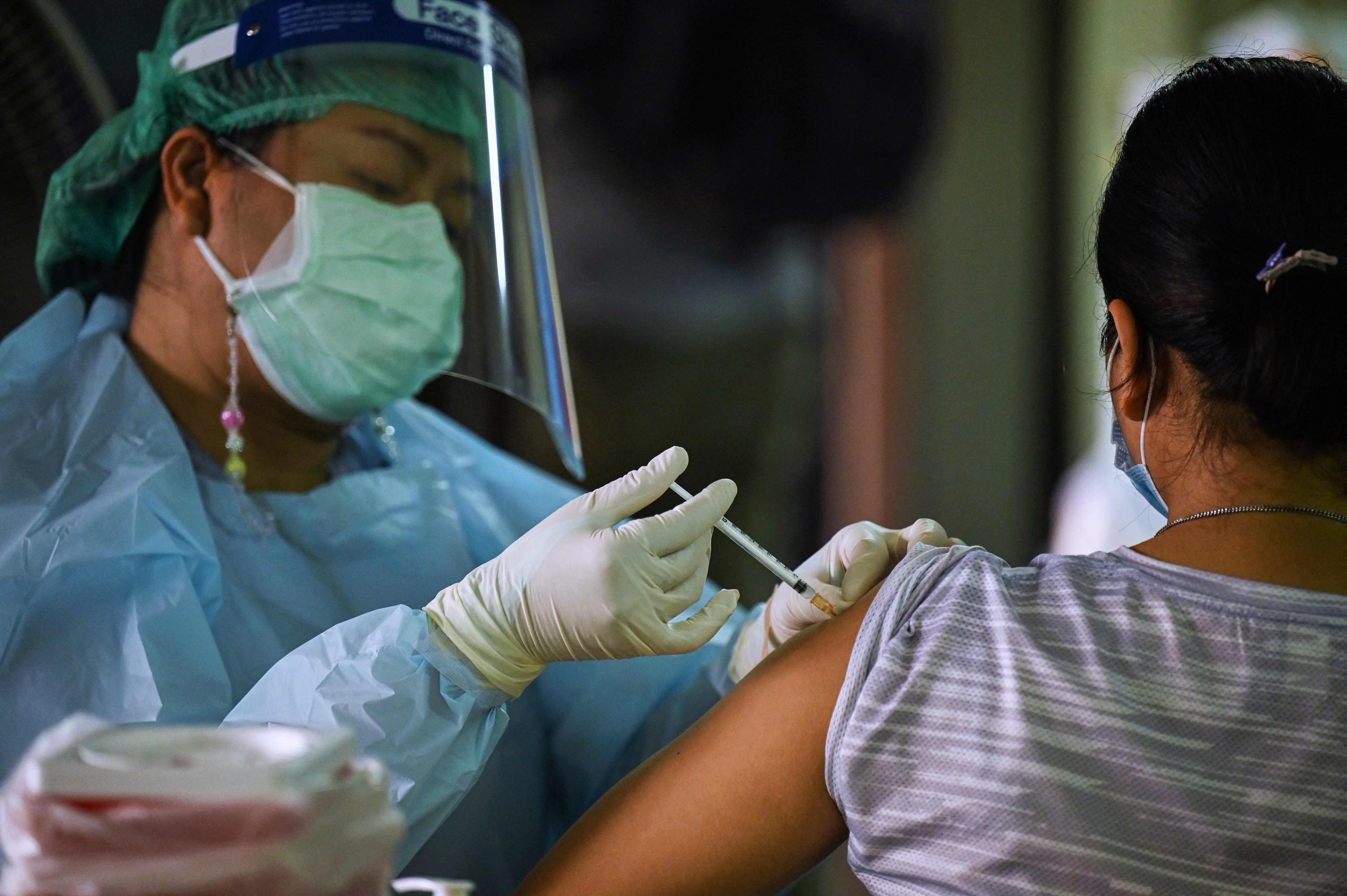 Un sanitario administra una vacuna de Sinovac en Tailandia.