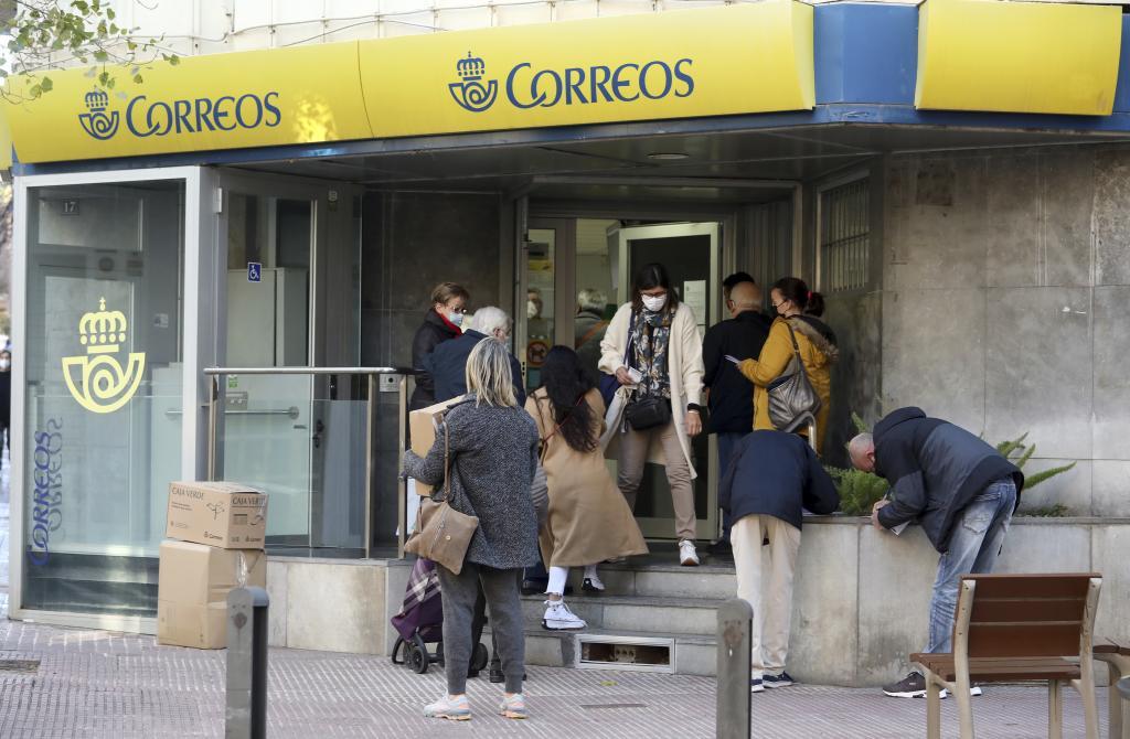Un grupo de personas en una oficina de Correos en Barcelona