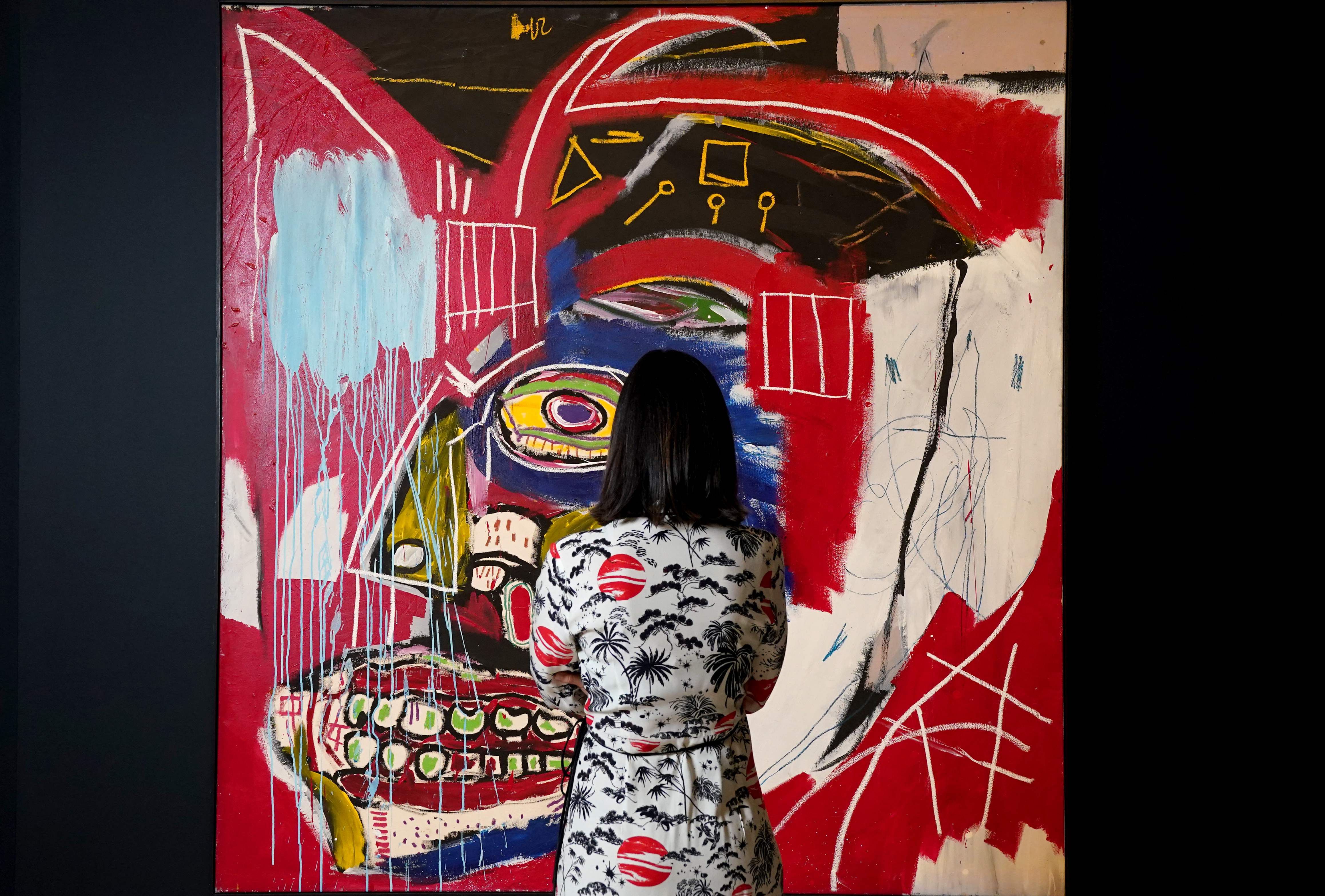 Una mujer contempla 'In this case', la obra de Basquiat suabastada este martes en Nueva York.
