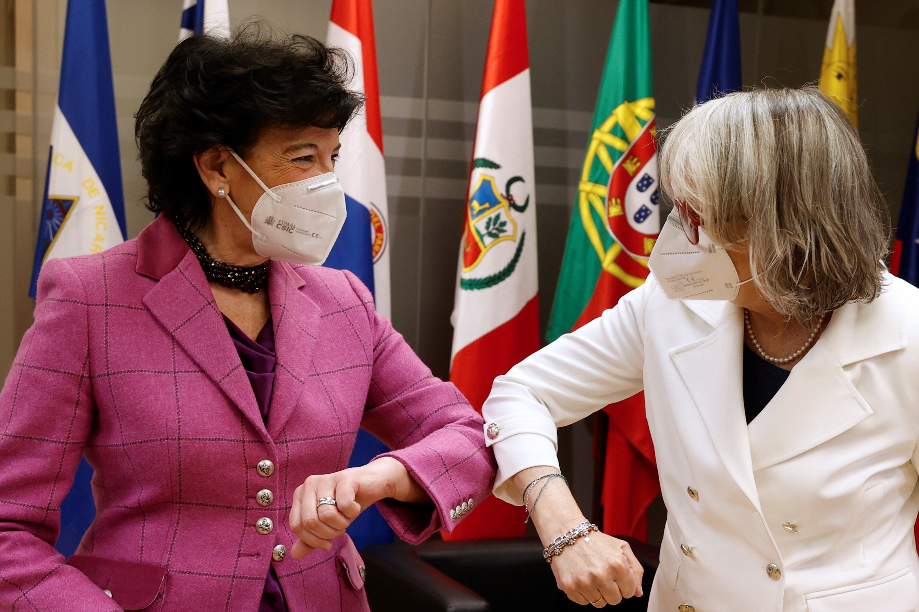 Celaá saluda con el codo a la presidenta de Efe, Gabriela Cañas, en un coloquio.