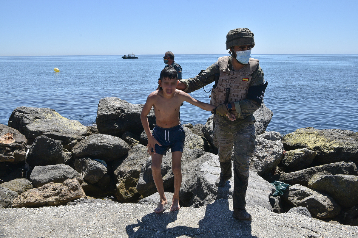 Un militar espaol ayuda a un menor llegado a nado a Ceuta.