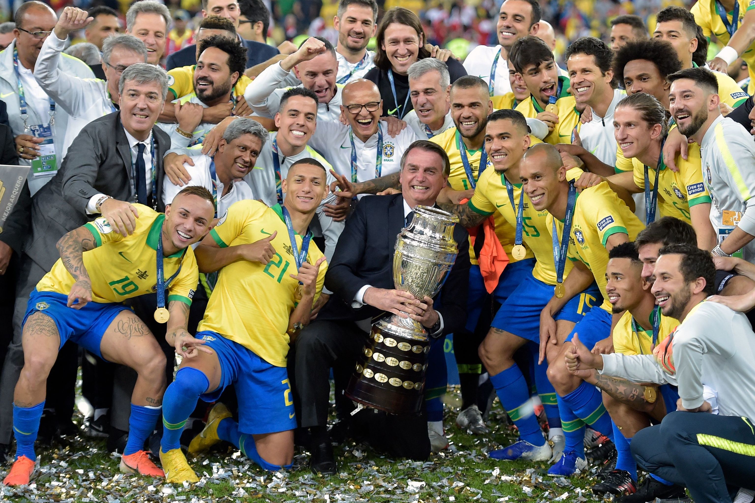 Jair Bolsonaro  sostiene el trofeo de la Copa América junto a la selección brasileña tras la final que ganaron a Perú en 2015.
