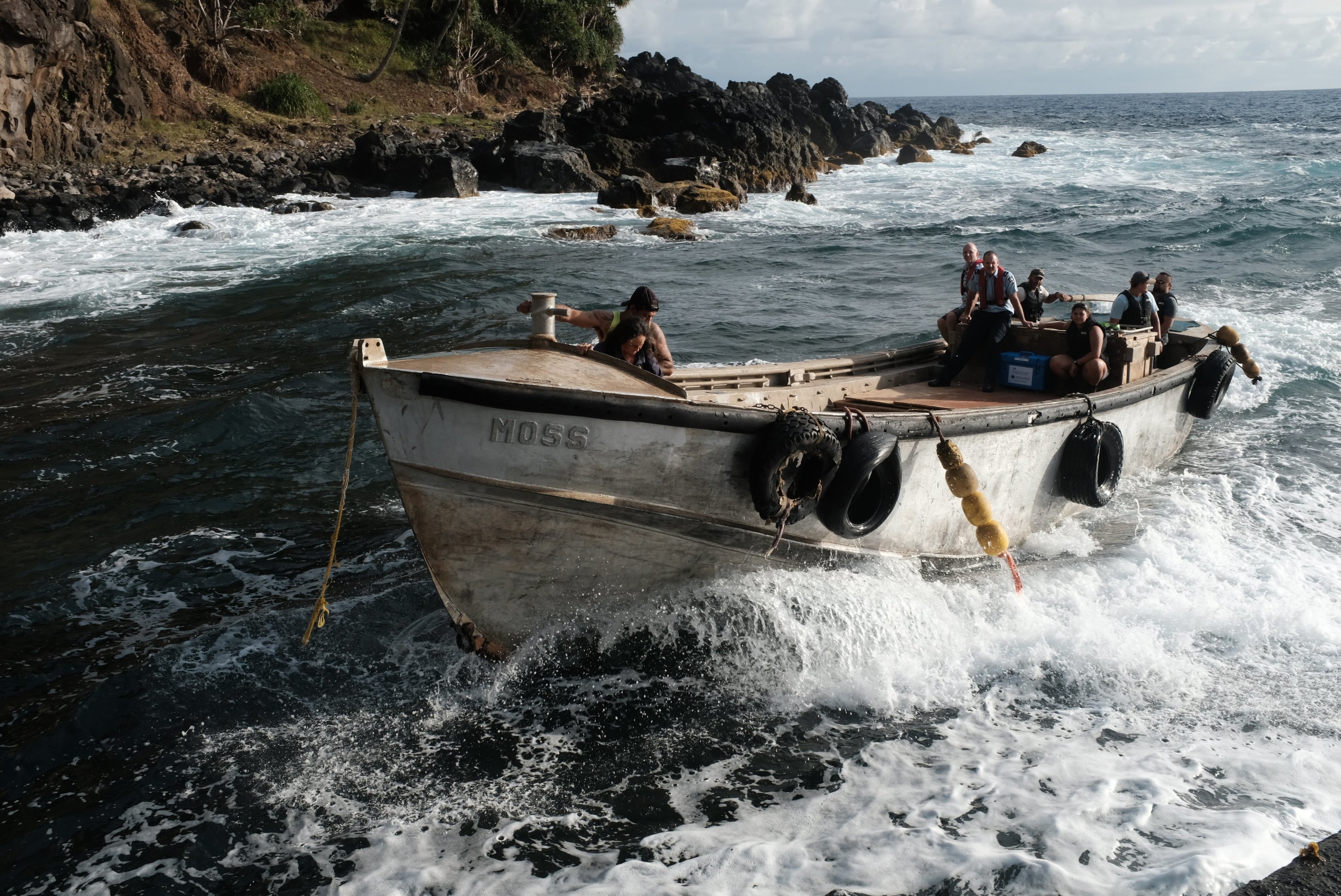 Un grupo de funcionarios británicos lleva las vacunas hasta la playa de la isla de Pitcairn.