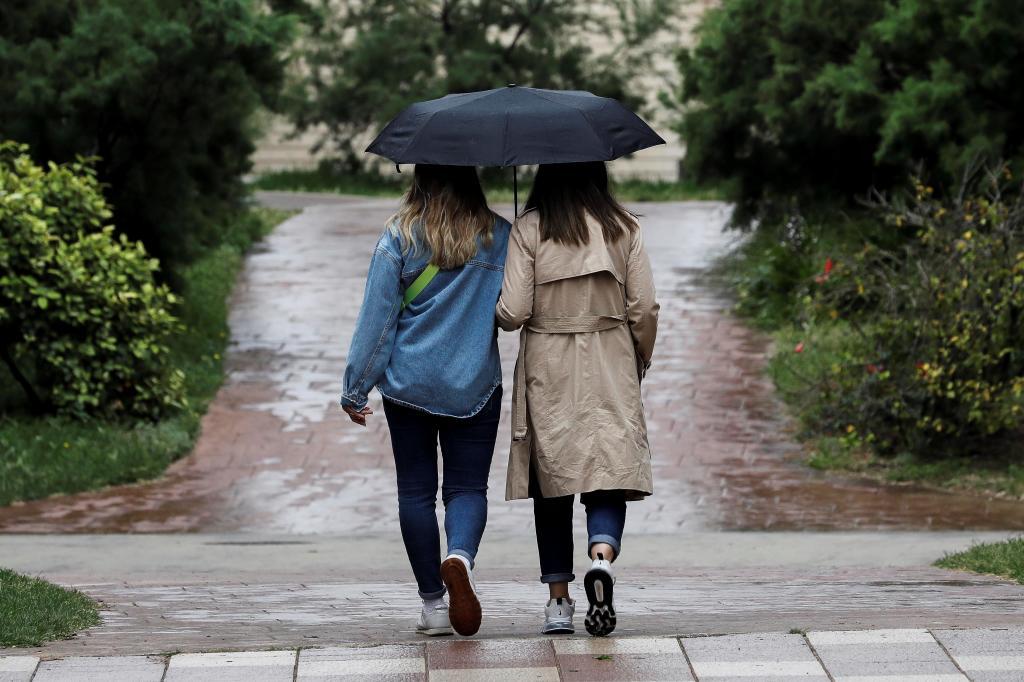 Dos personas se protegen de la lluvia en Valencia