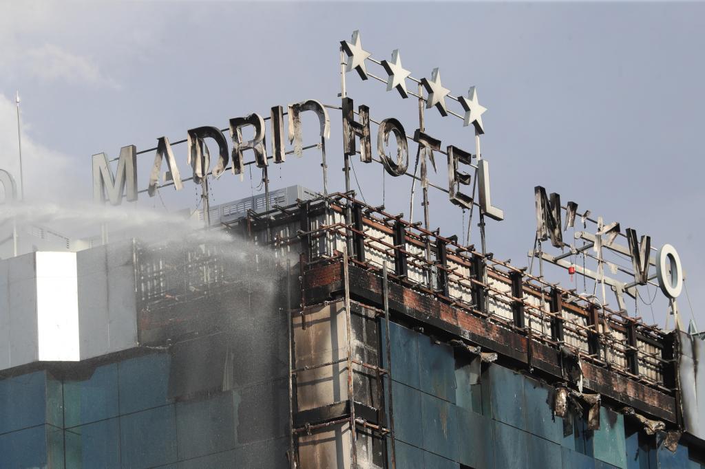 Los bomberos sofocan el incendio del hotel, que ha dejado daños en los rótulos de la fachada.