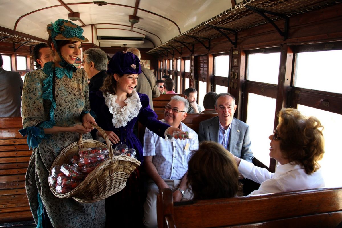 Azafatas vestida de poca amenizan a los pasajeros de El Tren de la Fresa.