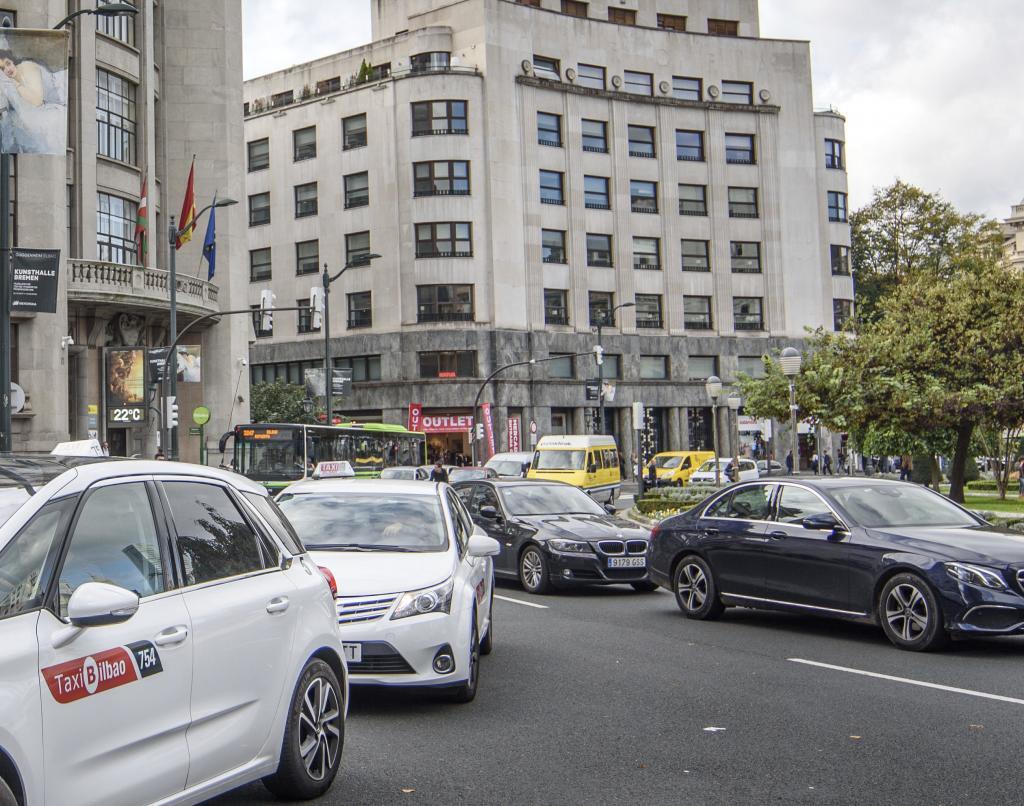 Vehculos de Uber circulan junto a varios taxis aparcados en la plaza Moyua de Bilbao.