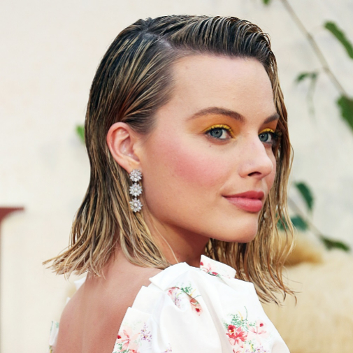 Margot Robbie con maquillaje en amarillo y peinado wet, un total look perfecto para el verano.