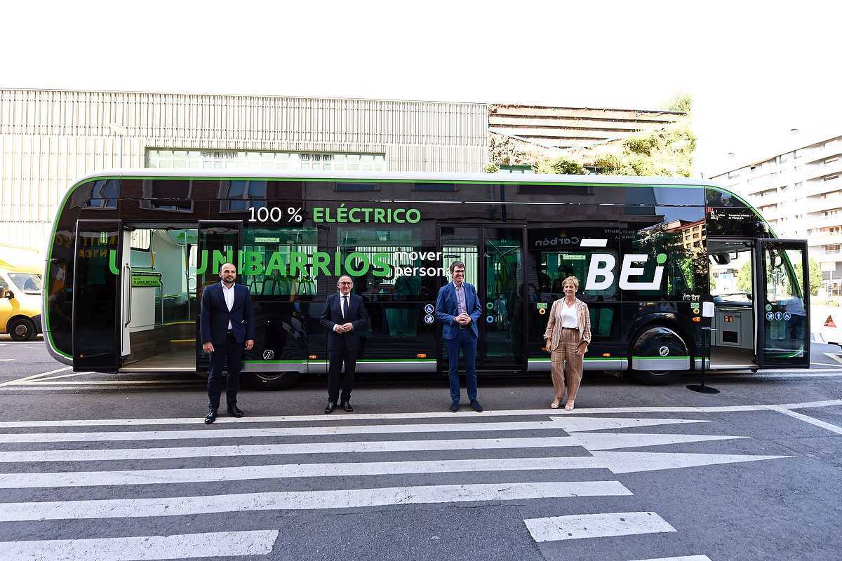 Los responsables institucionales del BEI en Vitoria posan junto a uno de los autobuses junto a un paso de cebra en el carril de los vehculos.