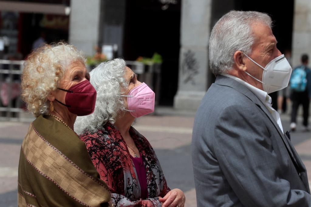 Varias personas con mascarilla, caminan este viernes por una calle de Madrid.