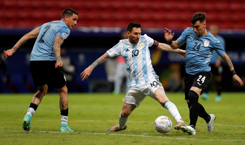 Lionel Messi disputa el baln con Fernando Gorriarn en el Argentina-Uruguay.