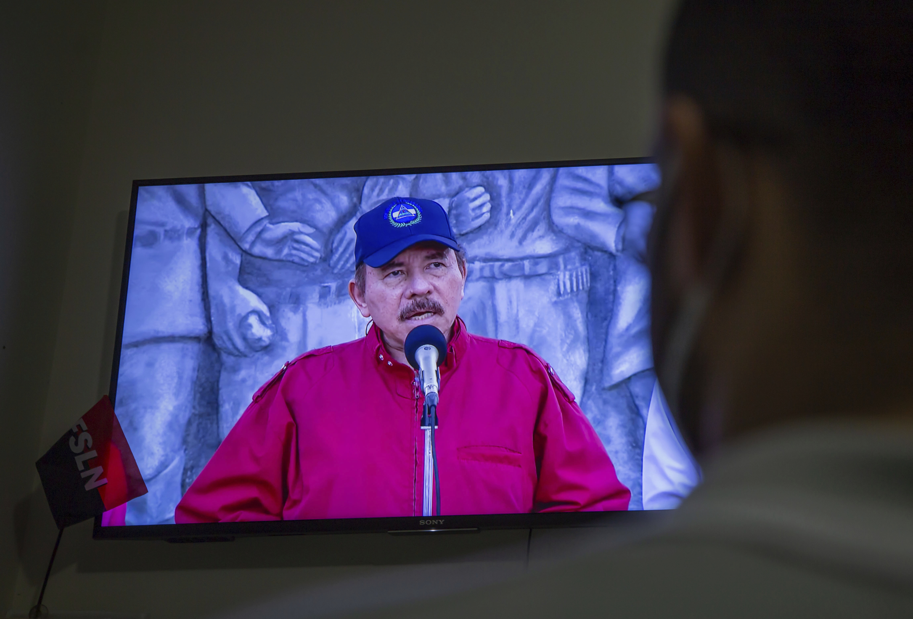 Un hombre ve la intervención de Daniel Ortega por televisión.