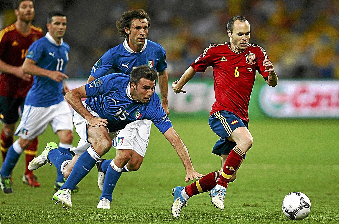 Iniesta, perseguido por jugadores de Italia en 2012.
