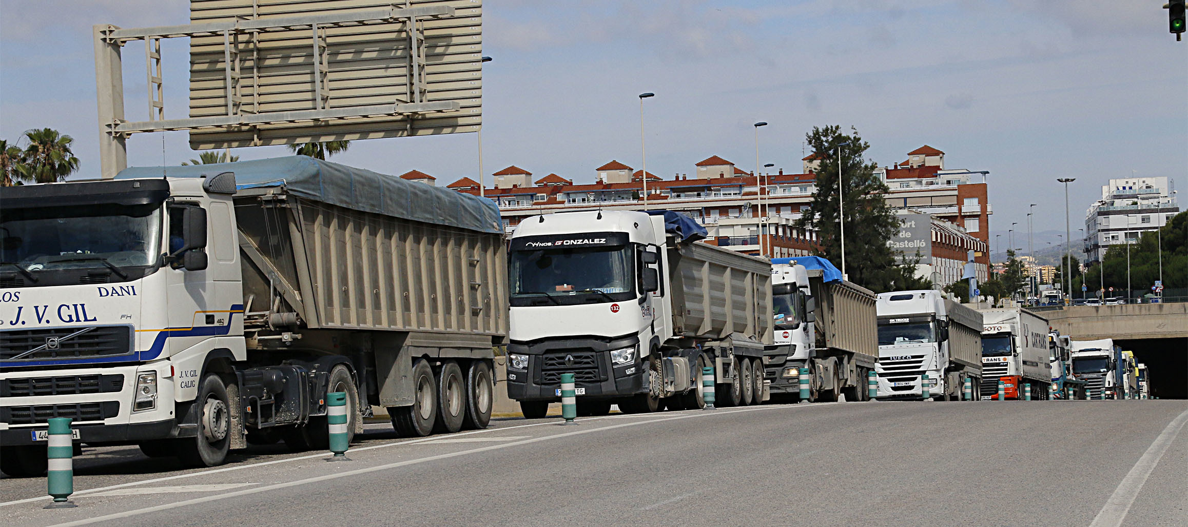 Camiones circulando por el acceso a PortCastell en el Grao.