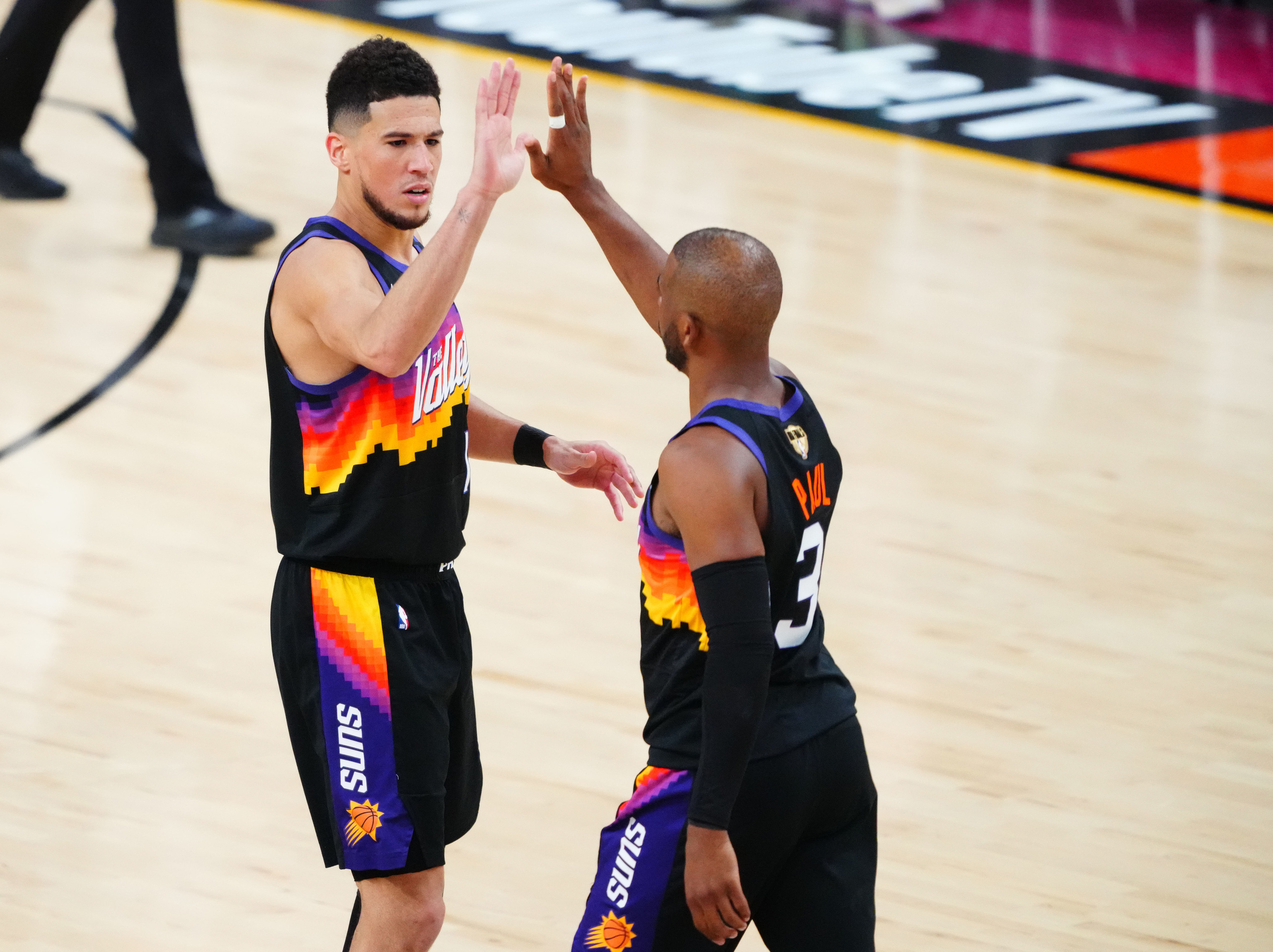 Devin Booker y Chris Paul, estrellas de los Suns, celebran un lance del partido.