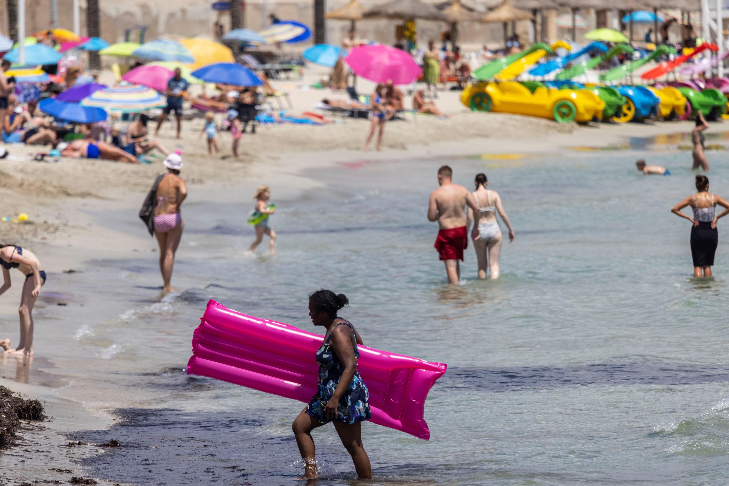 Turistas disfrutan del sol en la playa de Peguera, en el municipio mallorqun de Calvi.