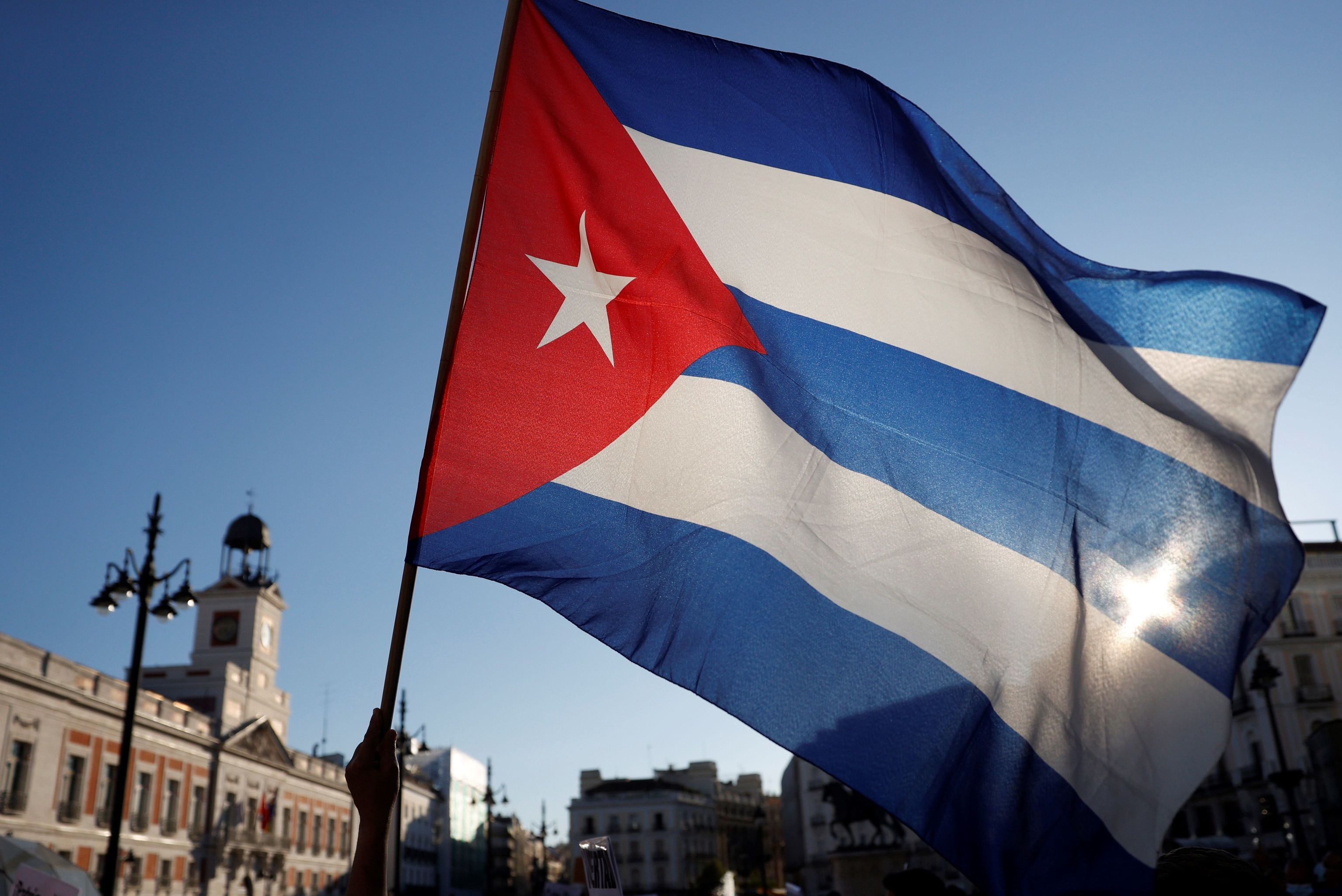 Una bandera de Cuba ante la Real Casa de Correos de la Puerta del Sol en una concentraci