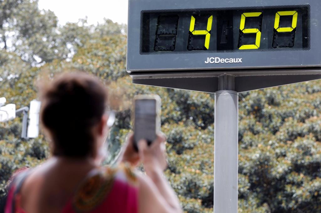 Una mujer hace una fotografa a un termmetro que marca 45 grados.