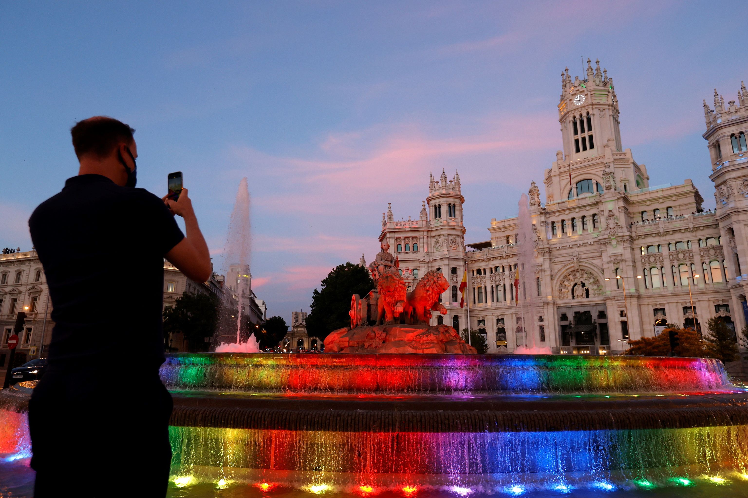 La fuente de Cibeles iluminada con los colores de la bandera LGTBI con motivo del inicio de la fiestas del Orgullo.
