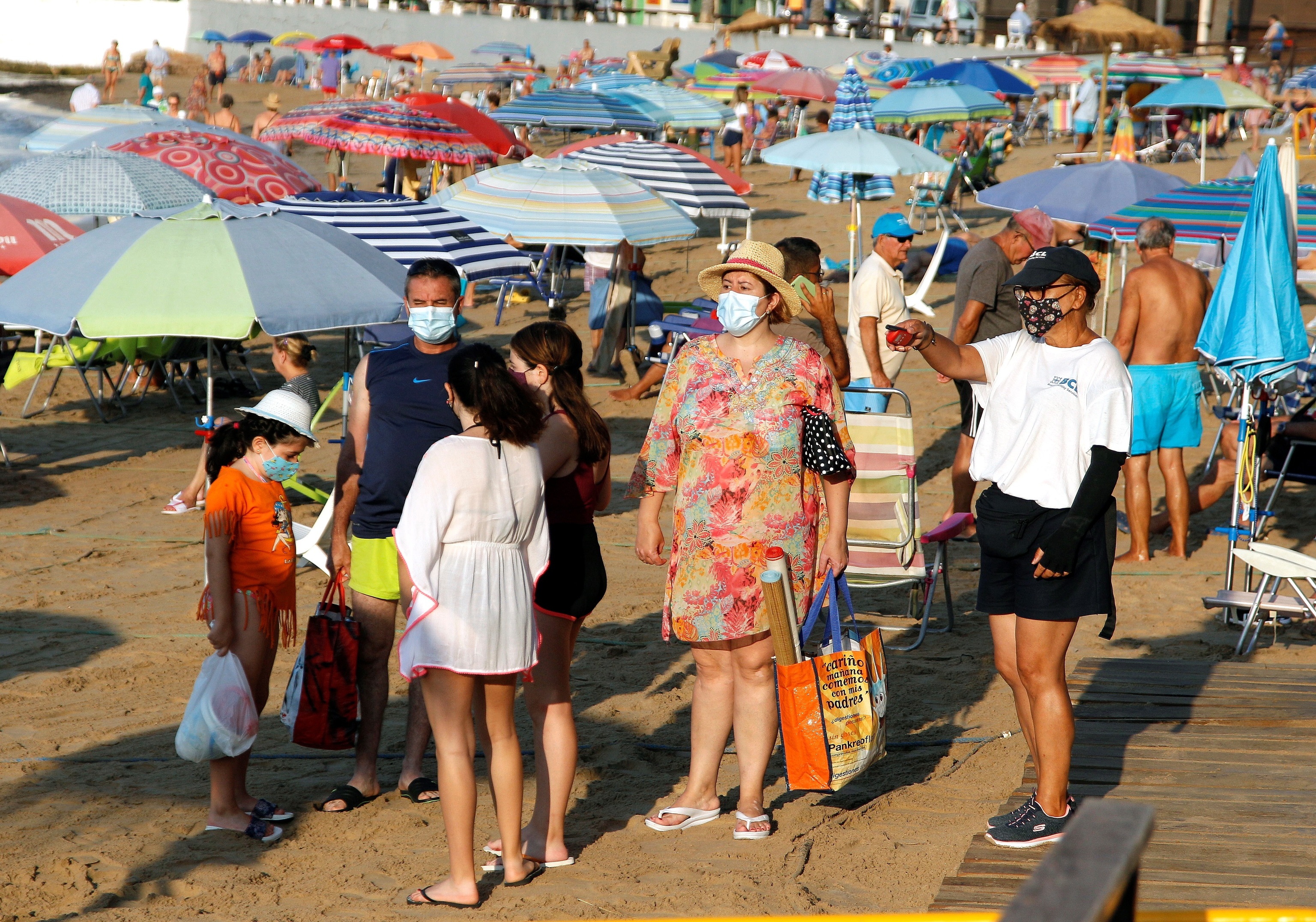 Un grupo de turistas se dispone a pasar un da en la playa del Cura de Torrevieja (Alicante).