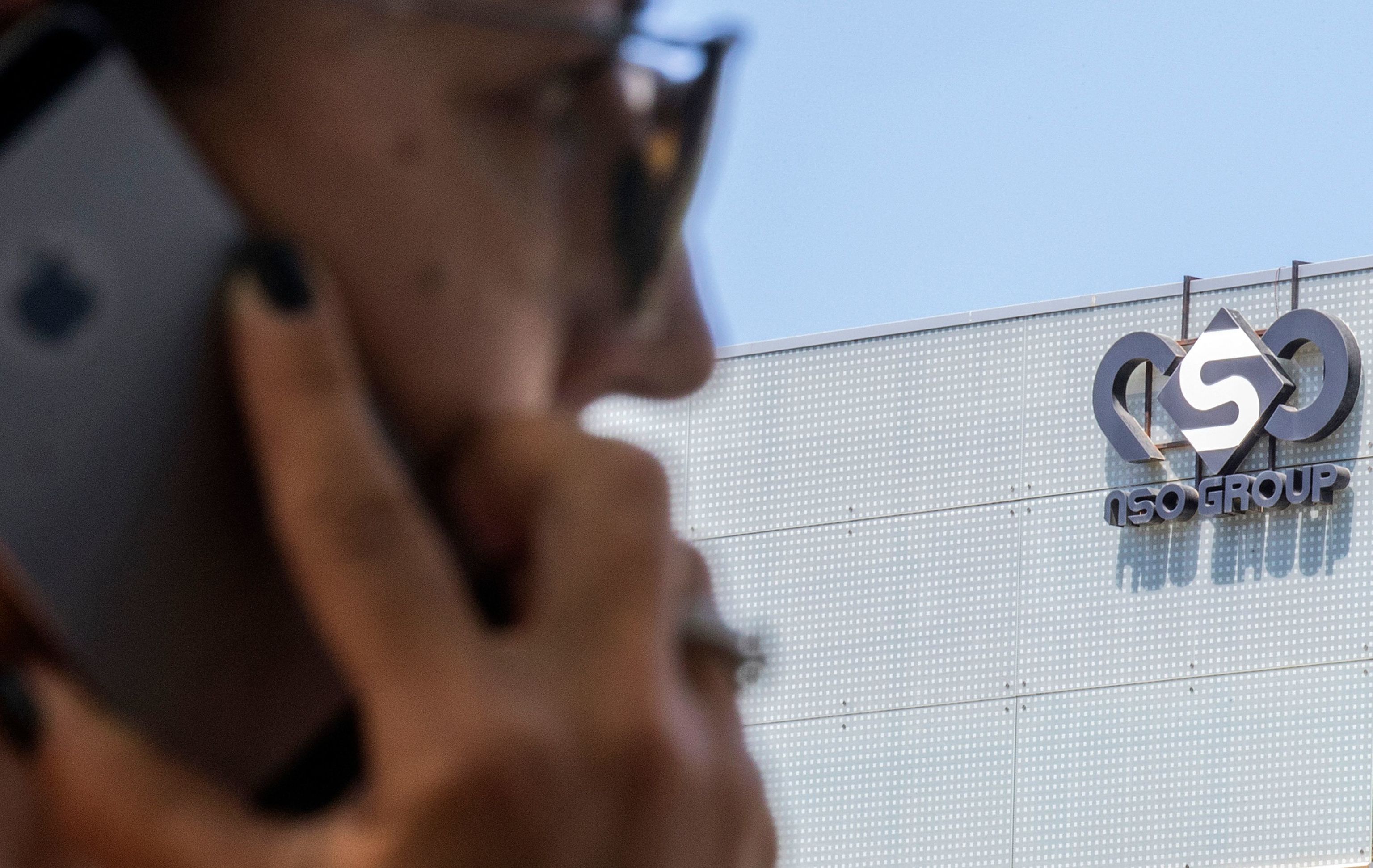 Una mujer usa su móvil frente al edificio del grupo israelí NSO, en Tel Aviv.