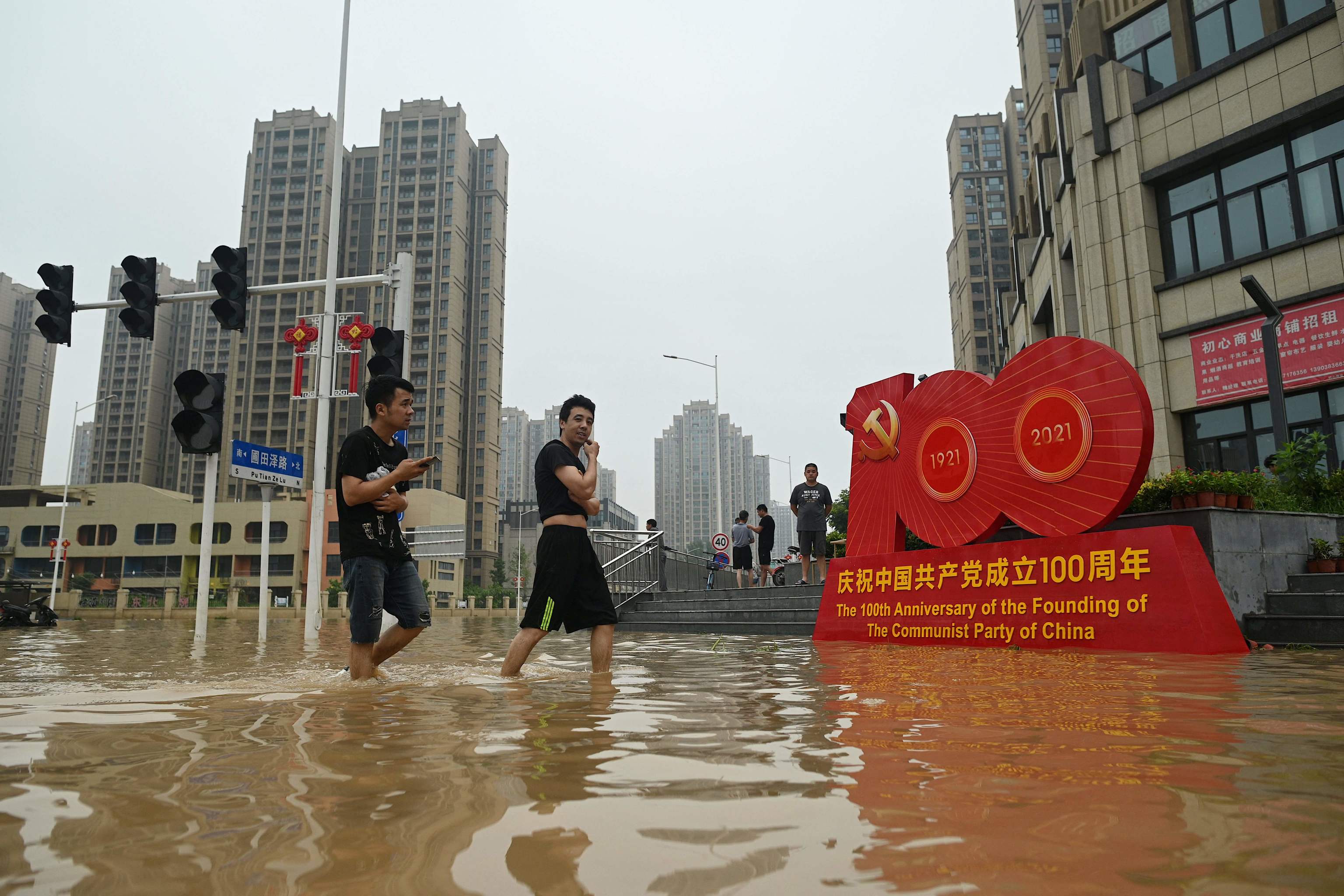 Ciudadanos atraviesan una calle inundada este jueves en la provincia de Henan, China.