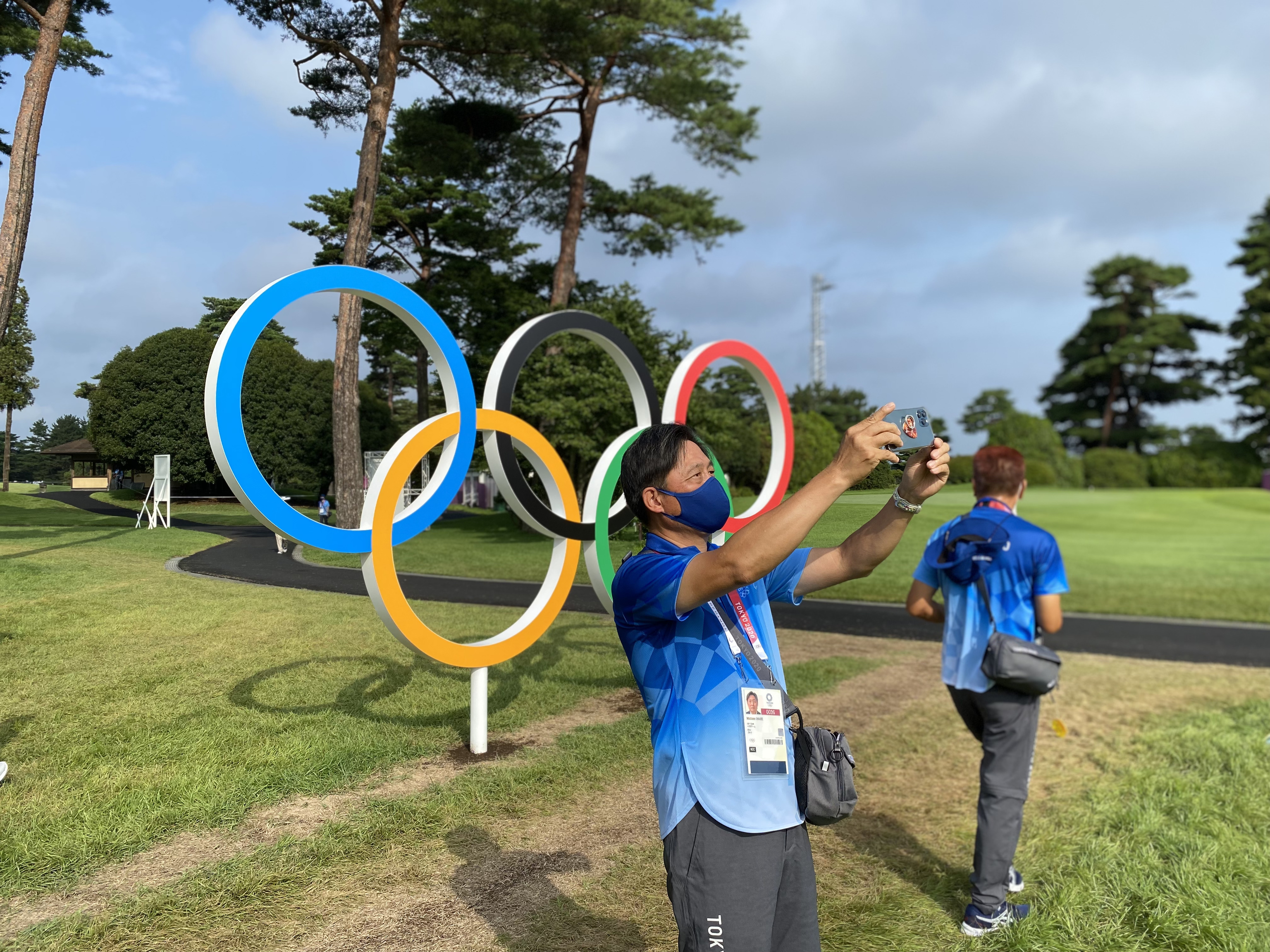 Los voluntarios se hacen selfies con los anillos olmpicos del campo de golf.