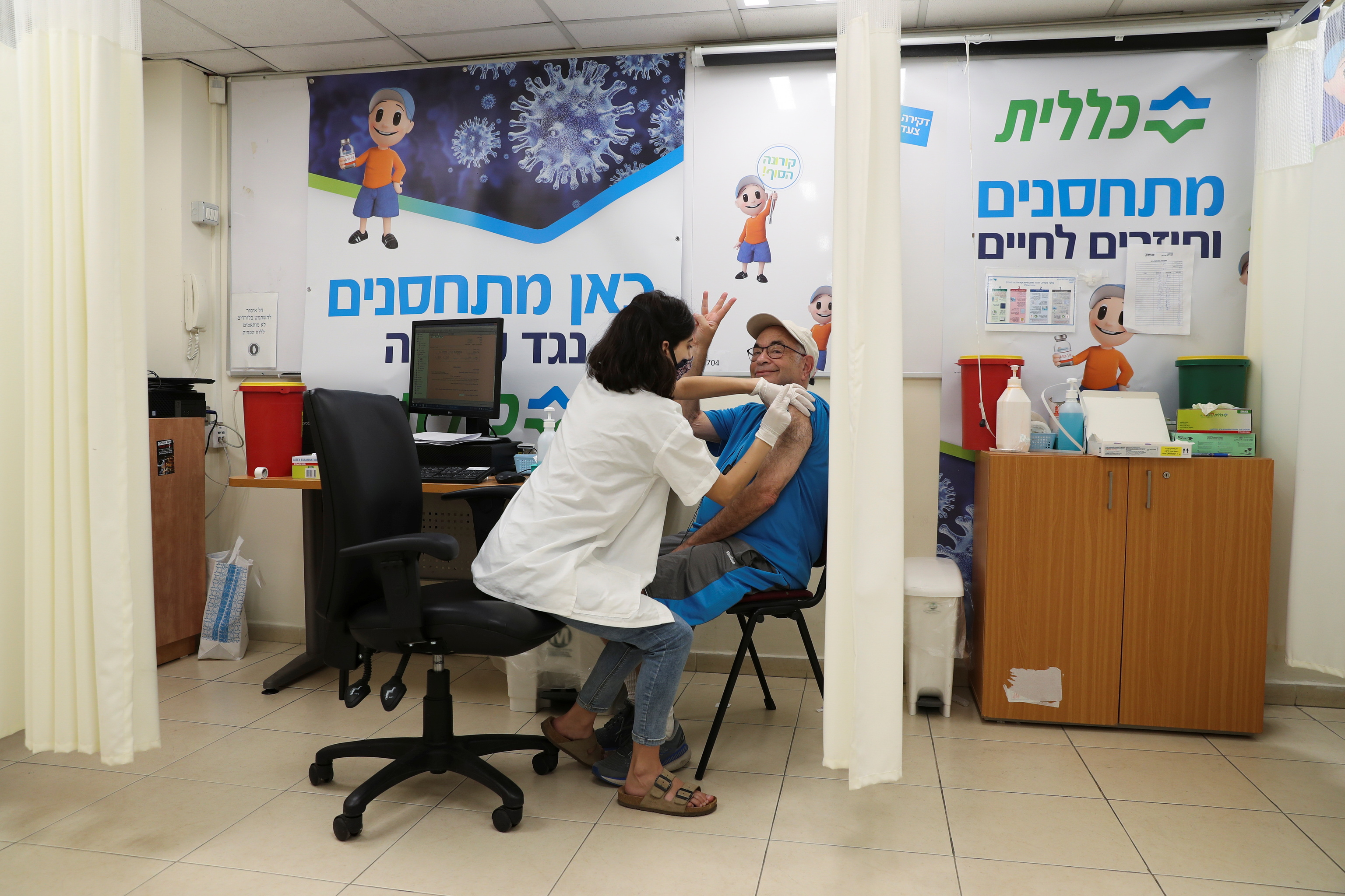 Un hombre gesticula mientras cibe su tercera dosis de la vacuna contra la enfermedad del coronavirus (COVID-19) en una organizacin de mantenimiento de la salud Clalit en Jerusaln