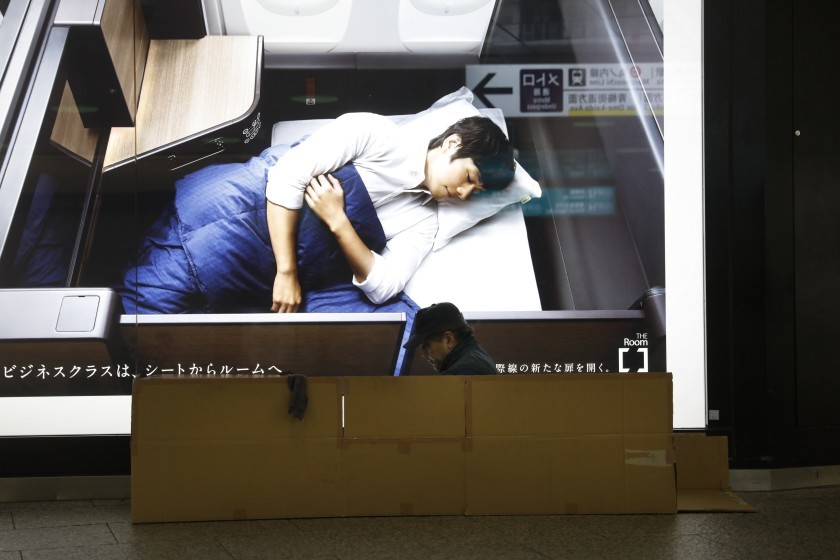 Un hombre sin hogar se prepara para dormir a la estacin Shinjuku, Tokio.