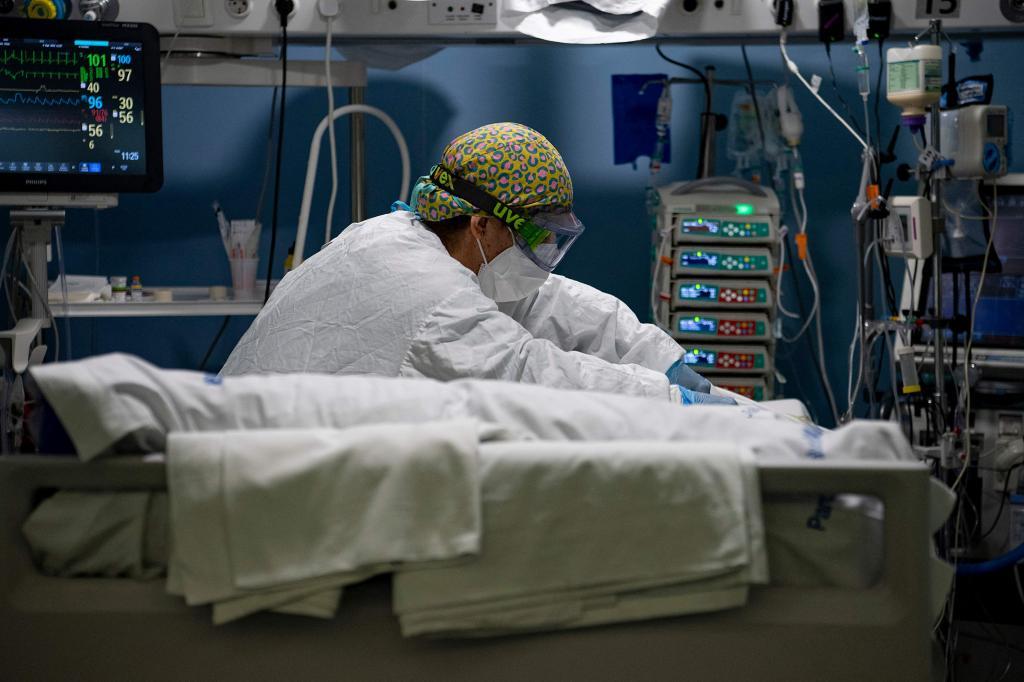 Una trabajadora atiende a un enfermo grave de Covid en la UCI del Hospital del Mar, en Barcelona