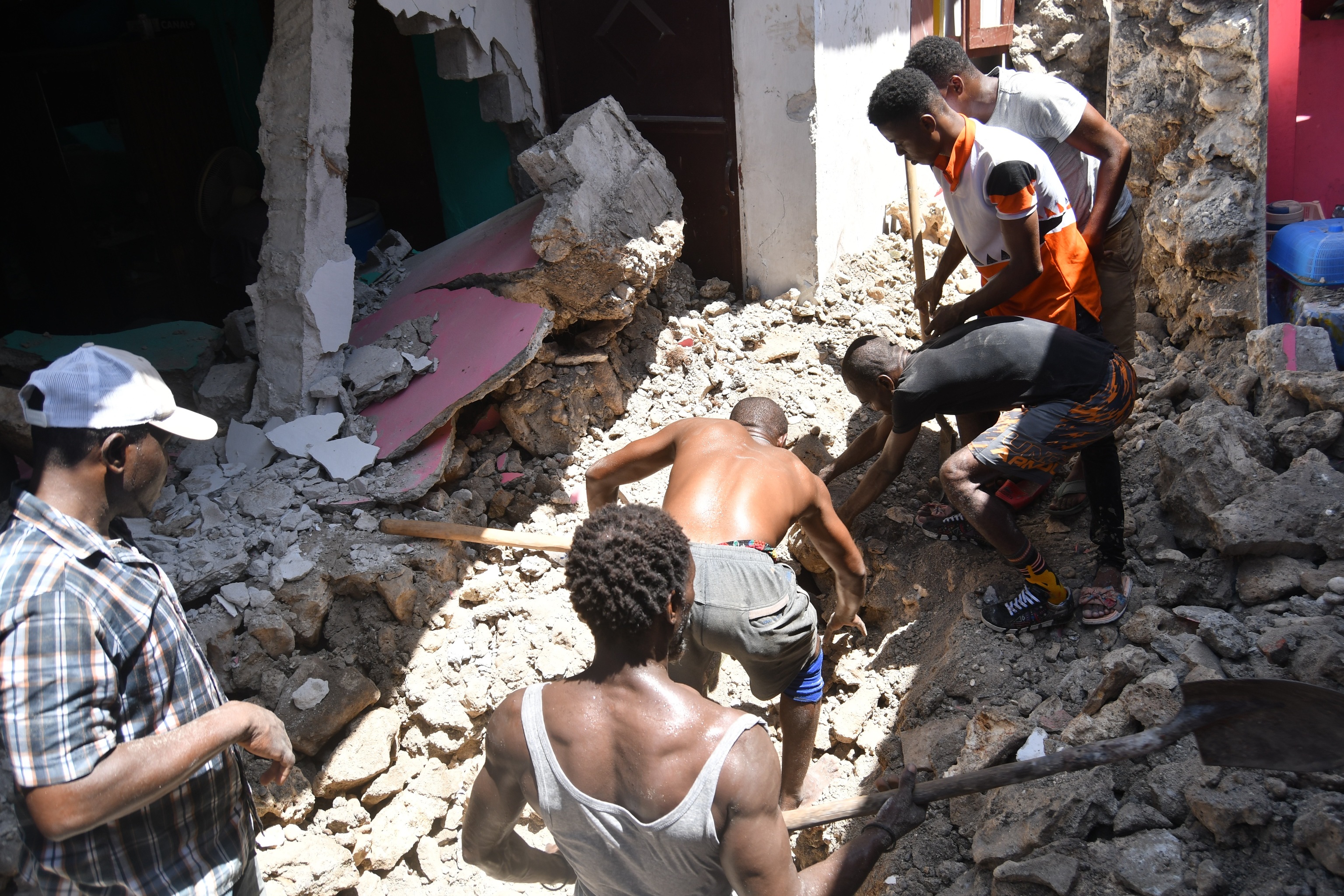 Un grupo de personas retira los escombros de una casa en Los Cayos.