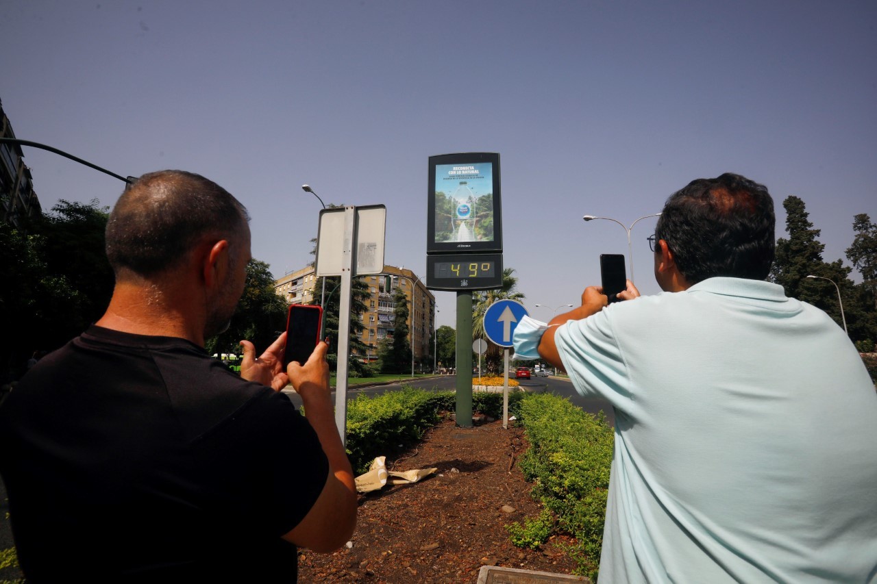 Dos ciudadanos fotografan un termmetro en una calle de Crdoba el sbado