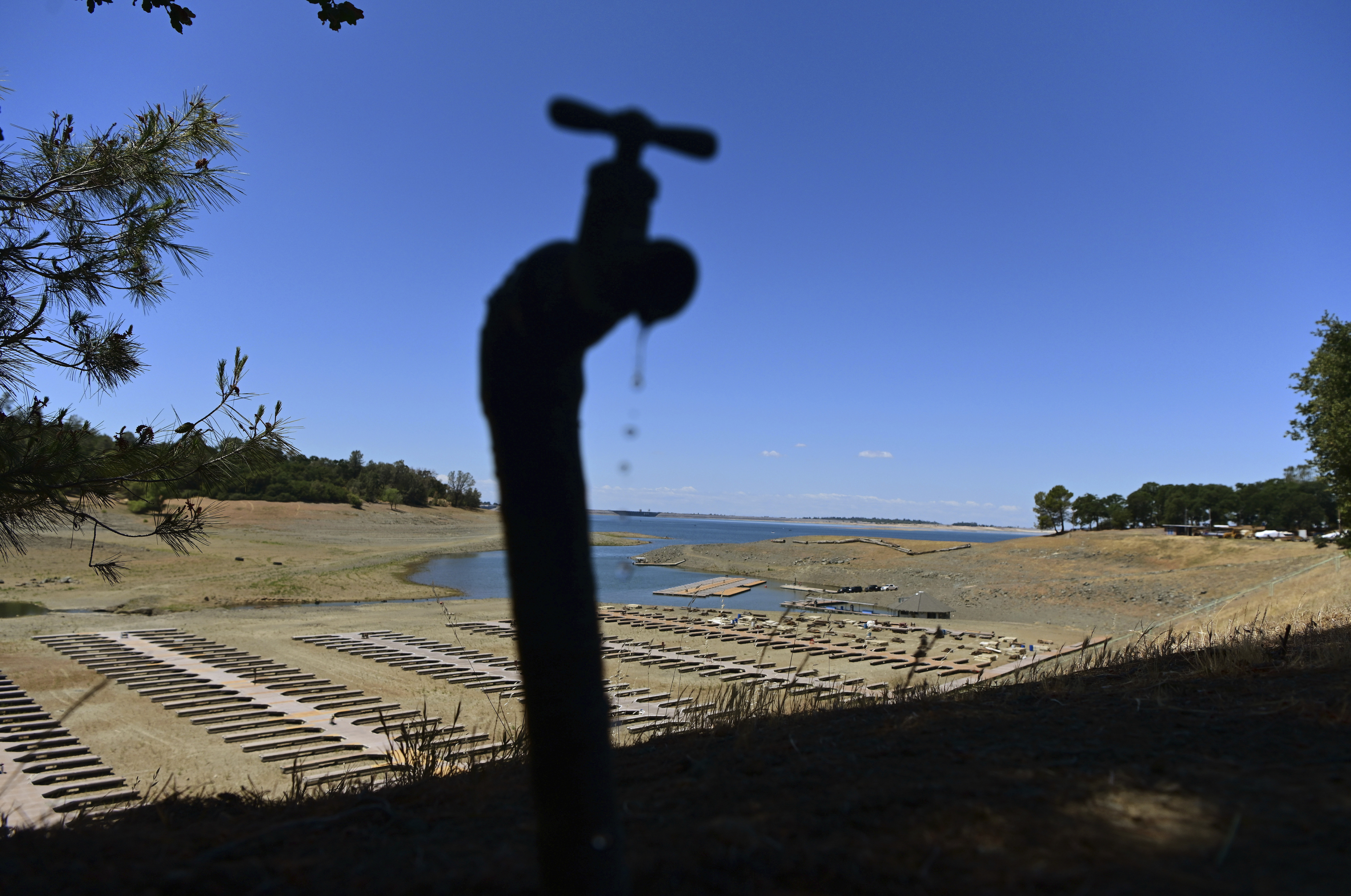 El agua gotea de un grifo cerca de los muelles para barcos que se encuentran en tierra firme en la zona de Browns Ravine Cove del lago Folsom, afectado por la sequa, en Folsom, California.