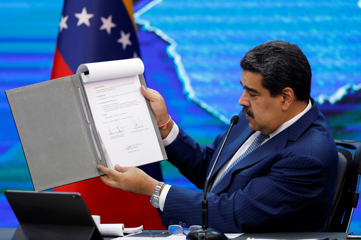 Nicolás Maduro muestra un documento firmado con la oposición, en Caracas.