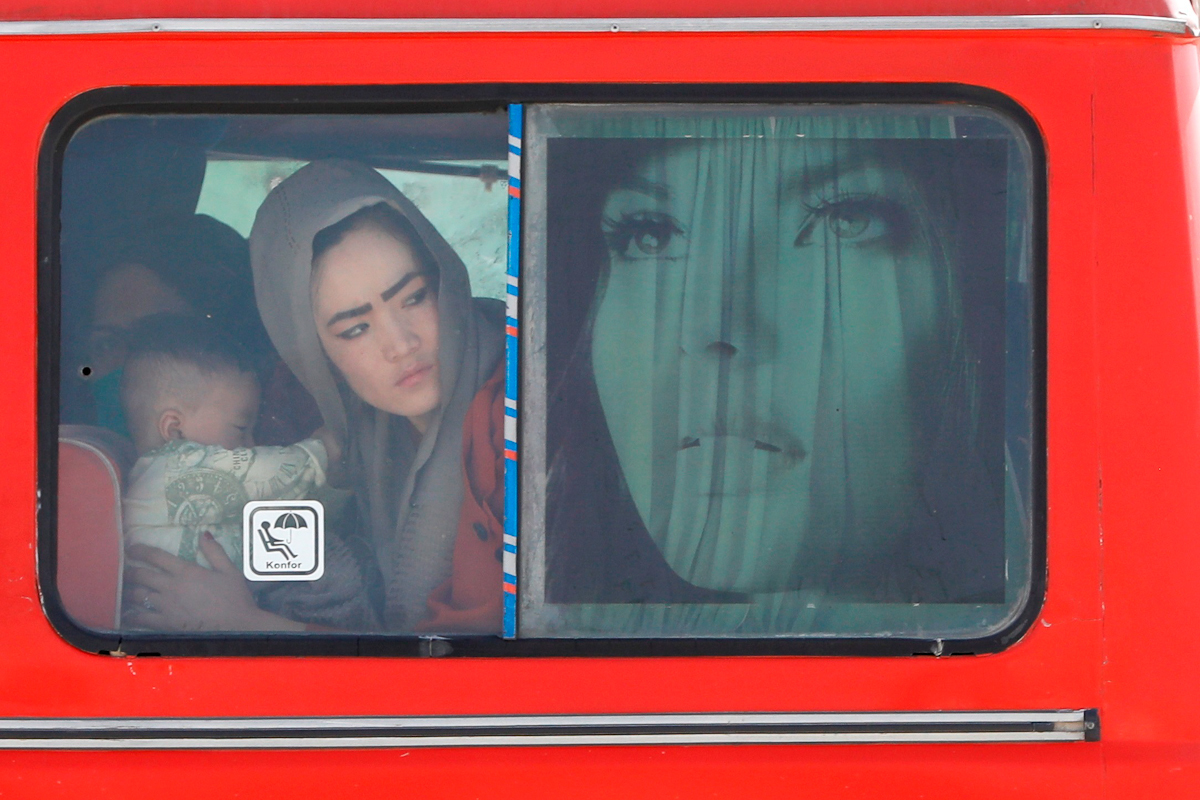 Mujeres afganas cruzan la frontera con Irn en autobs.
