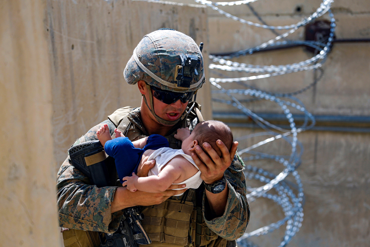 Un marine consuela a un bebé mientras espera a su madre en Kabul.