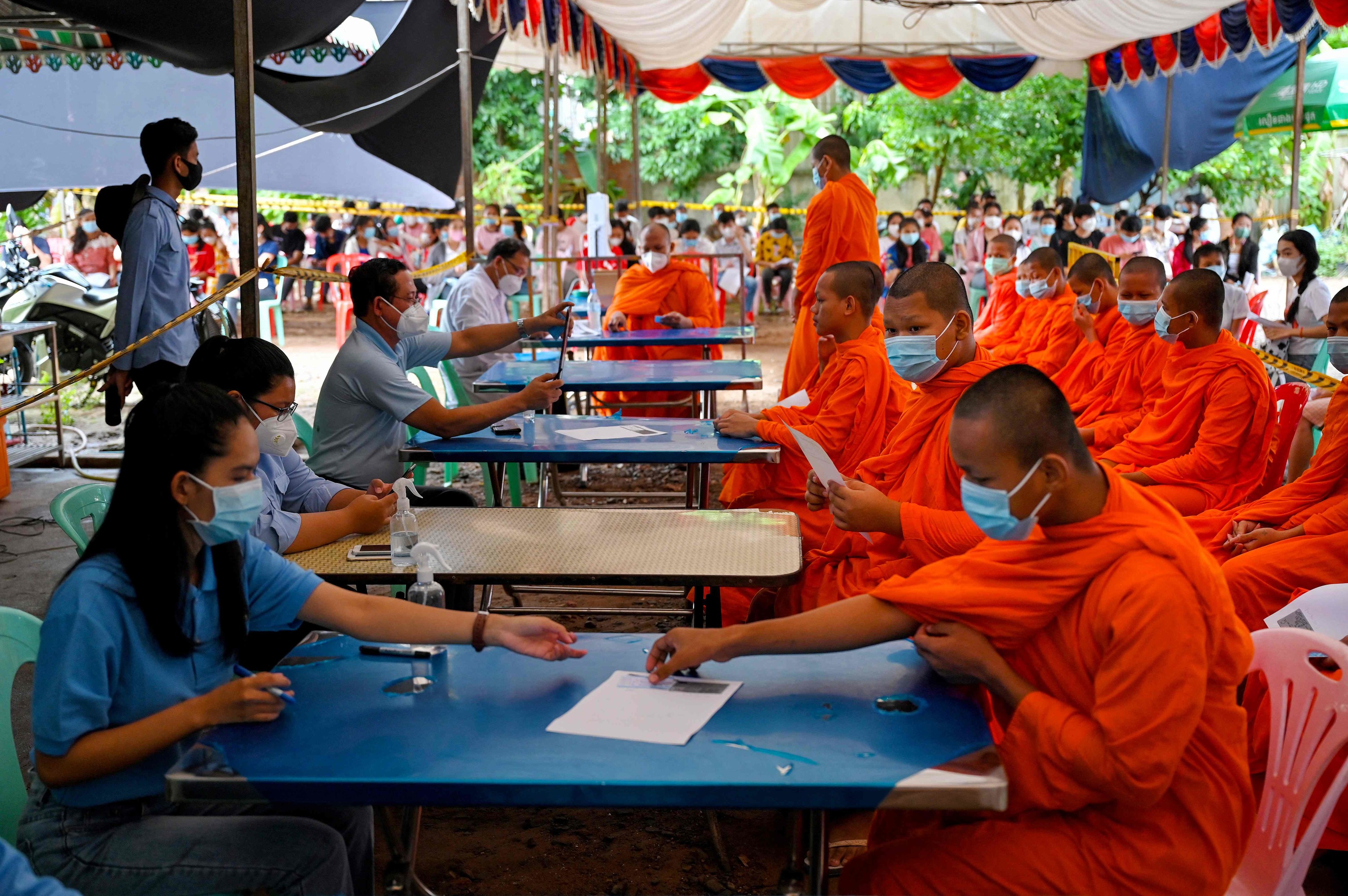 Monjes budistas rellenan formularios para acceder a la vacuna Sinovac en Camboya.