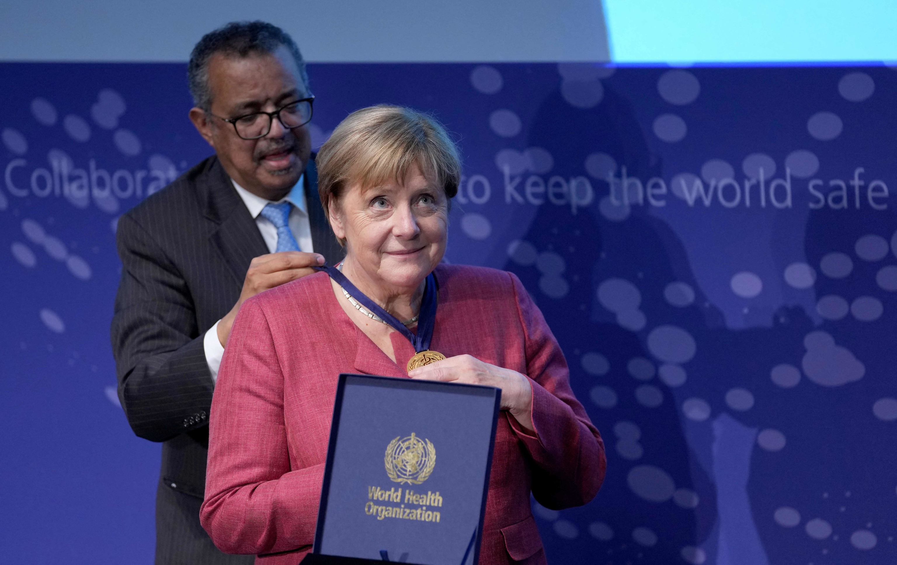 La canciller alemana Angela Merkel (d) recibe una medalla de manos del director general de la Organizacin Mundial de la Salud (OMS), Tedros Adhanom Ghebreyesus, en la ceremonia de inauguracin del "WHO Hub For Pandemic And Epidemic Intelligence" en el edificio Langenbeck-Virchow de Berln, el 1 de septiembre de 2021.