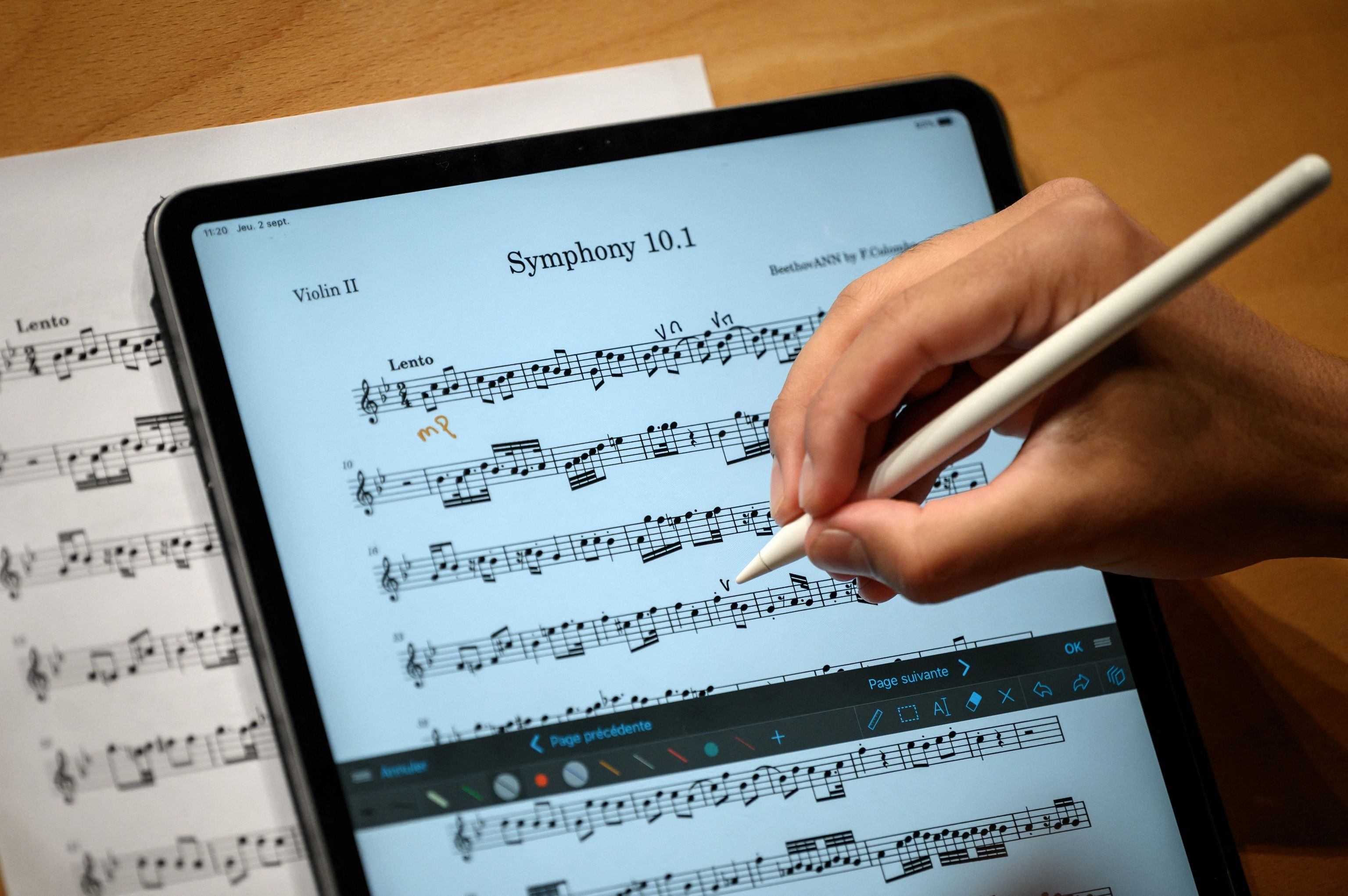 Un miembro de la orquesta de Nexus anota una partitura musical en su tablet