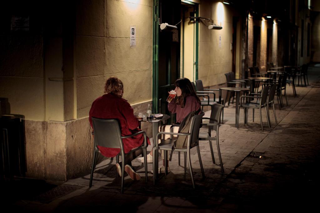 Dos jóvenes en la terraza de un bar de Valencia.