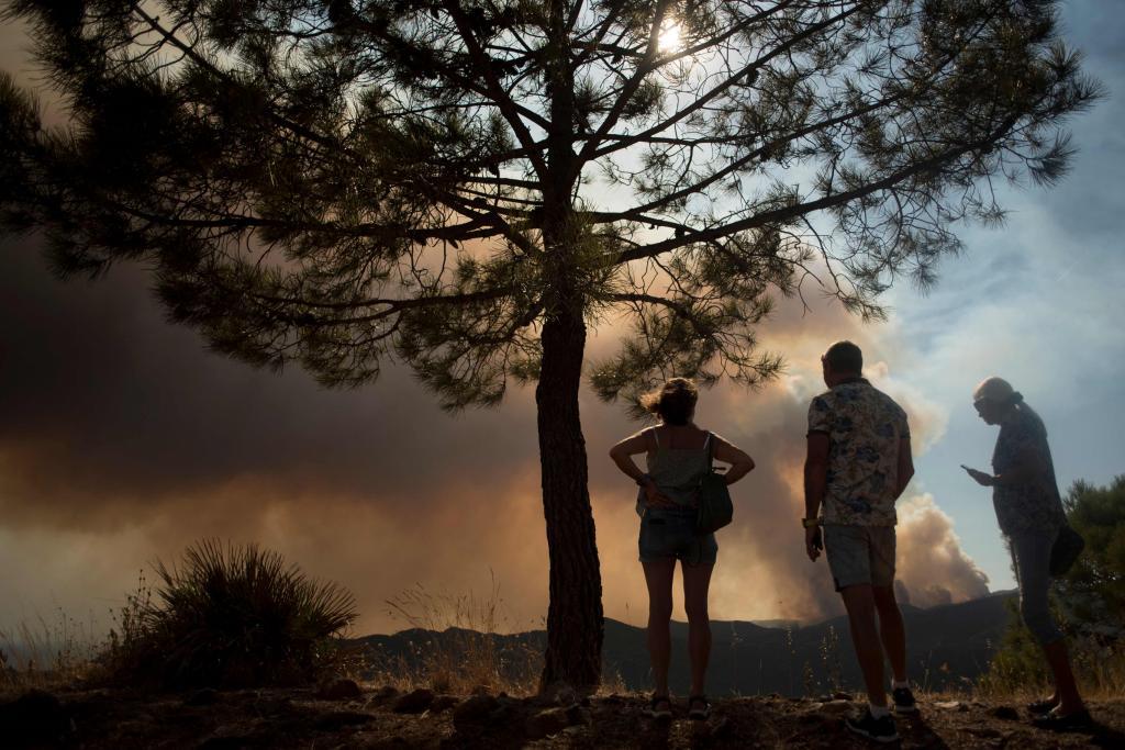 Unas personas observan desde Benahavs la enorme nube de humo producida por el incendio de Sierra Bermeja.