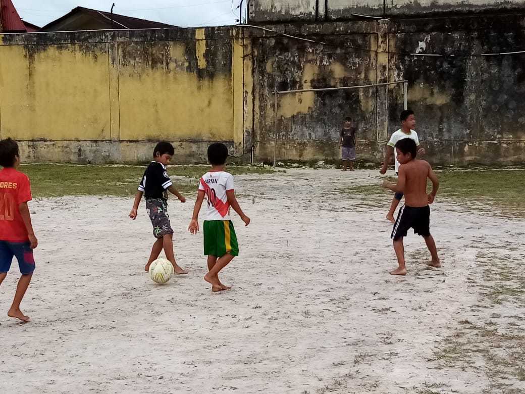 Varios nios jugando al ftbol en el patio de un colegio de la Amazonia peruana.