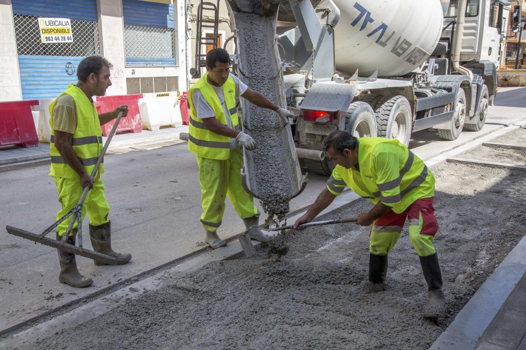 Unos operarios trabajan en el asfaltado de una calle de Valencia.