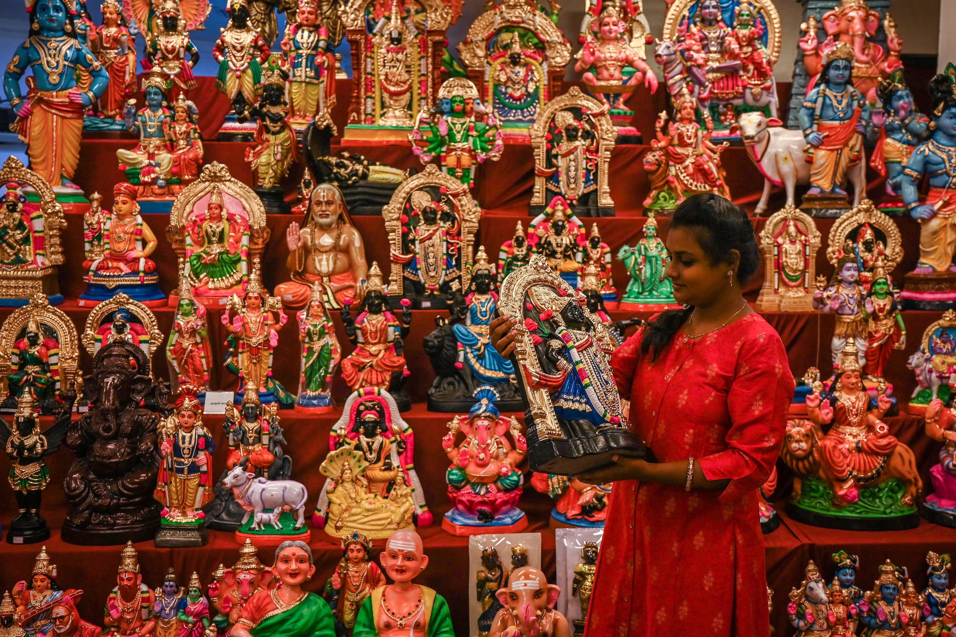 Una mujer contempla estatuillas de dioses del hindusmo, en Chennai.