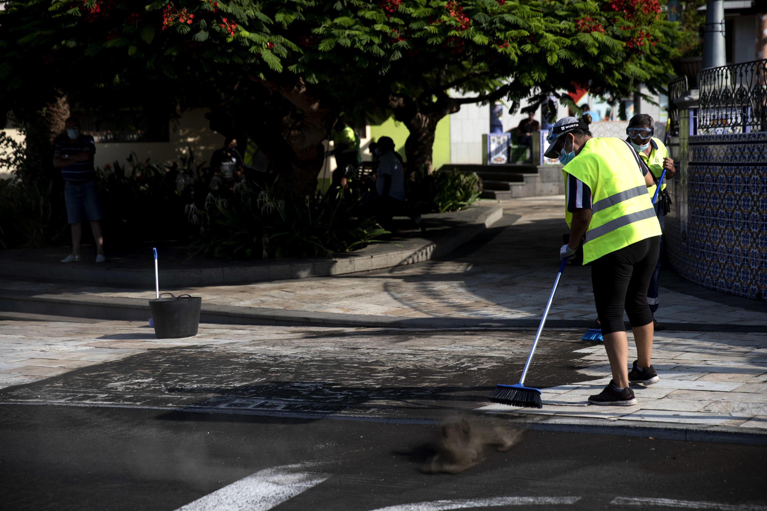 Varias personas limpian en Tazacorte la ceniza que cubre la isla de La Palma, tras la erupcin del volcn Cumbre Vieja.