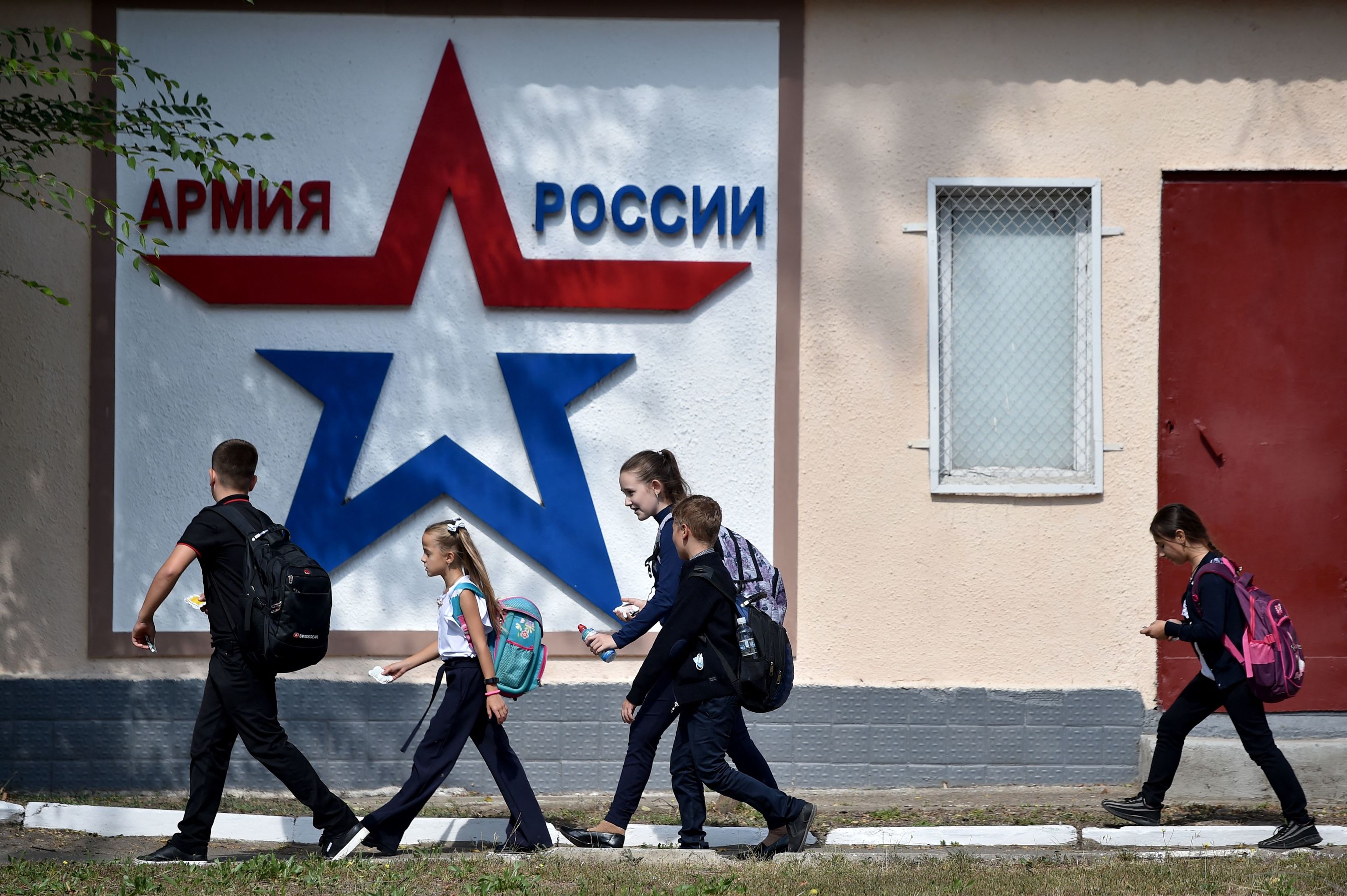 Cuatro nios caminan por delante del edificio del ejrcito ruso en Tirspol.