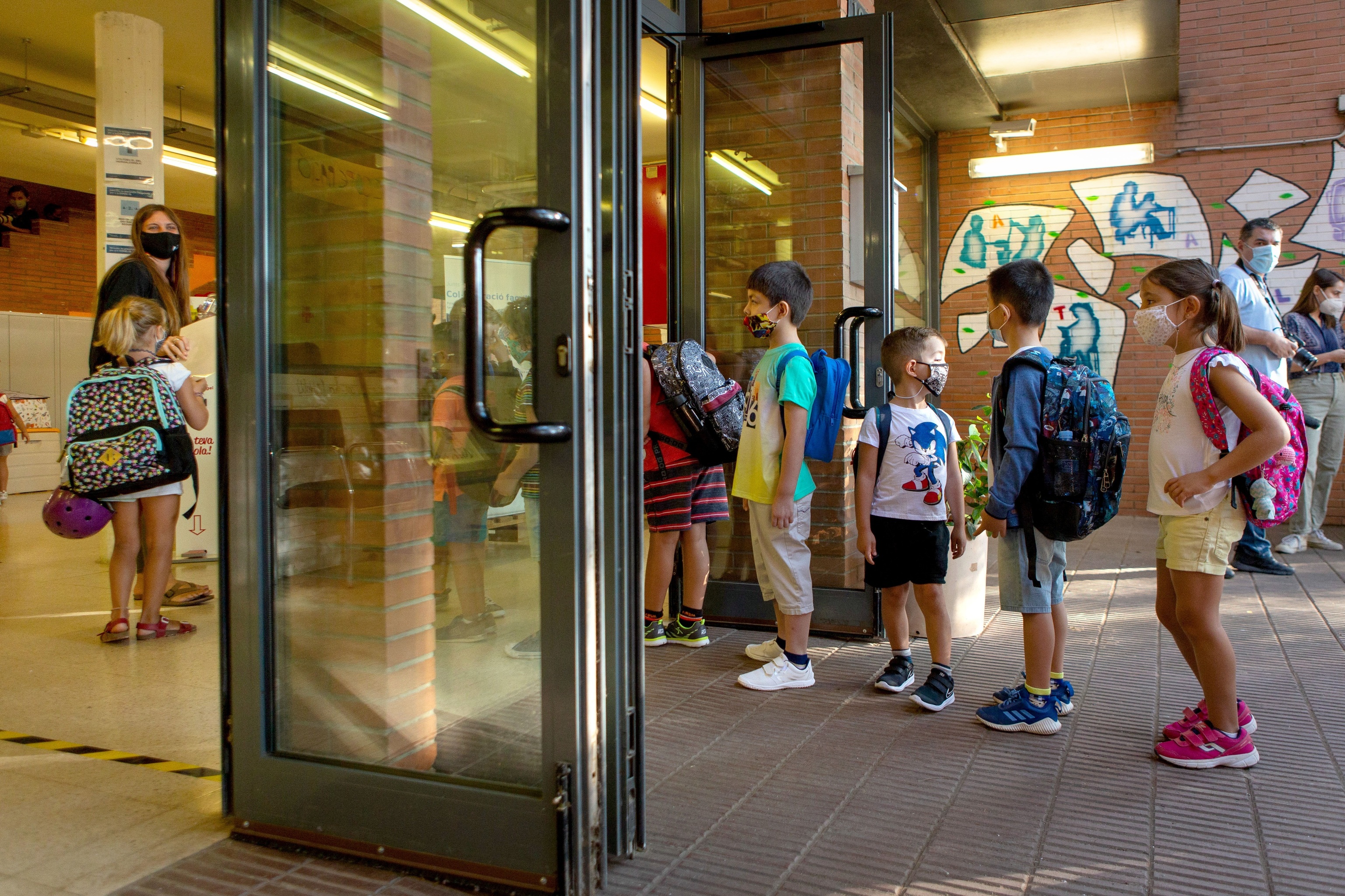 Varios niños hacen cola para entrar en la Escola Catalonia de Barcelona al comienzo de curso en septiembre.
