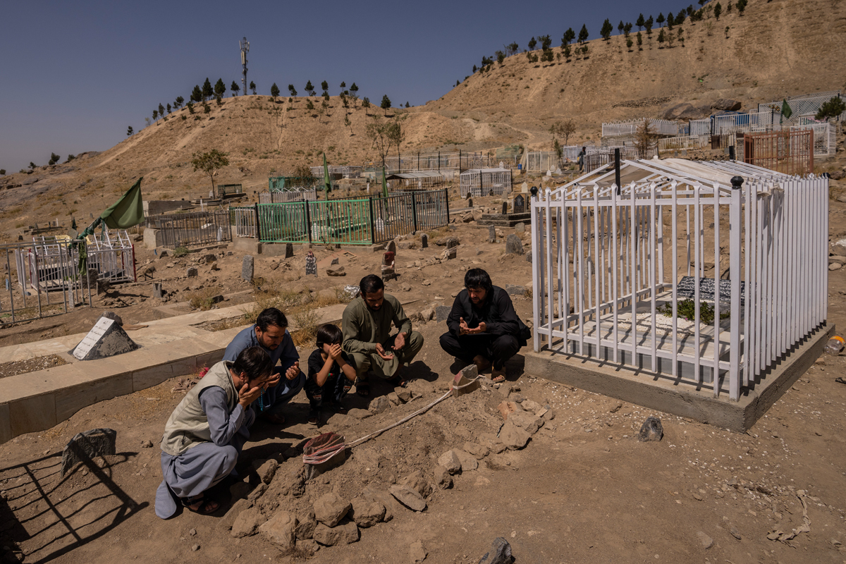 Un grupo reza junto a las tumbas de sus familiares, asesinados por un dron en Kabul.