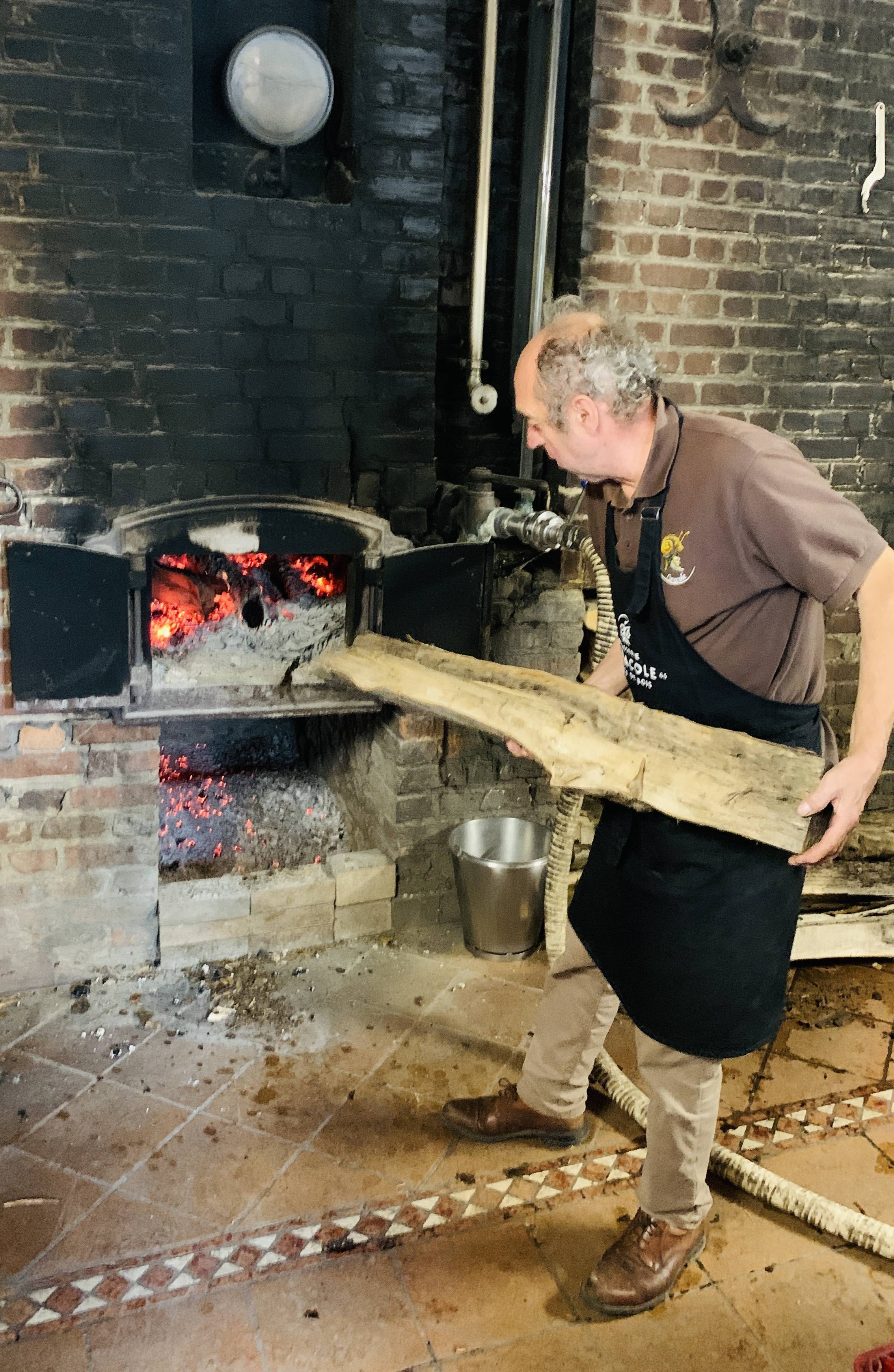 Philippe Attout introduce un tronco en el horno.